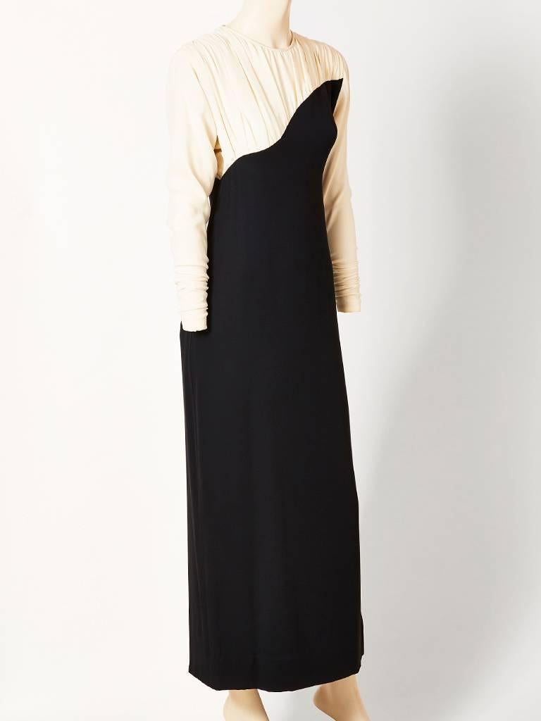 Galanos, 1940's inspired, black and white crepe evening dress, having an ivory crepe, asymmetric upper bodice that is draped along the neckline and shoulders with a dolman sleeve. The balance of the dress is black crepe, semi fitted. C. 1980's.