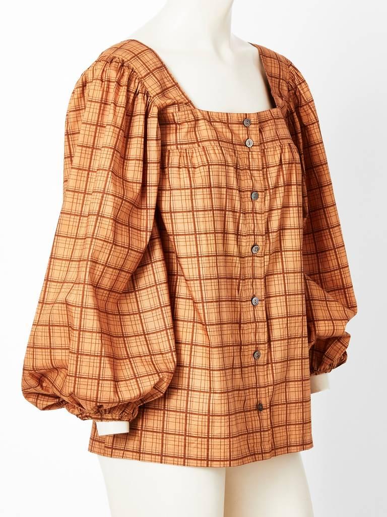 Yves Saint Laurent, rive gauche, warm toned, silk, smock blouse having a window pane plaid pattern, square neckline and blouson sleeves. C. 1970's.
