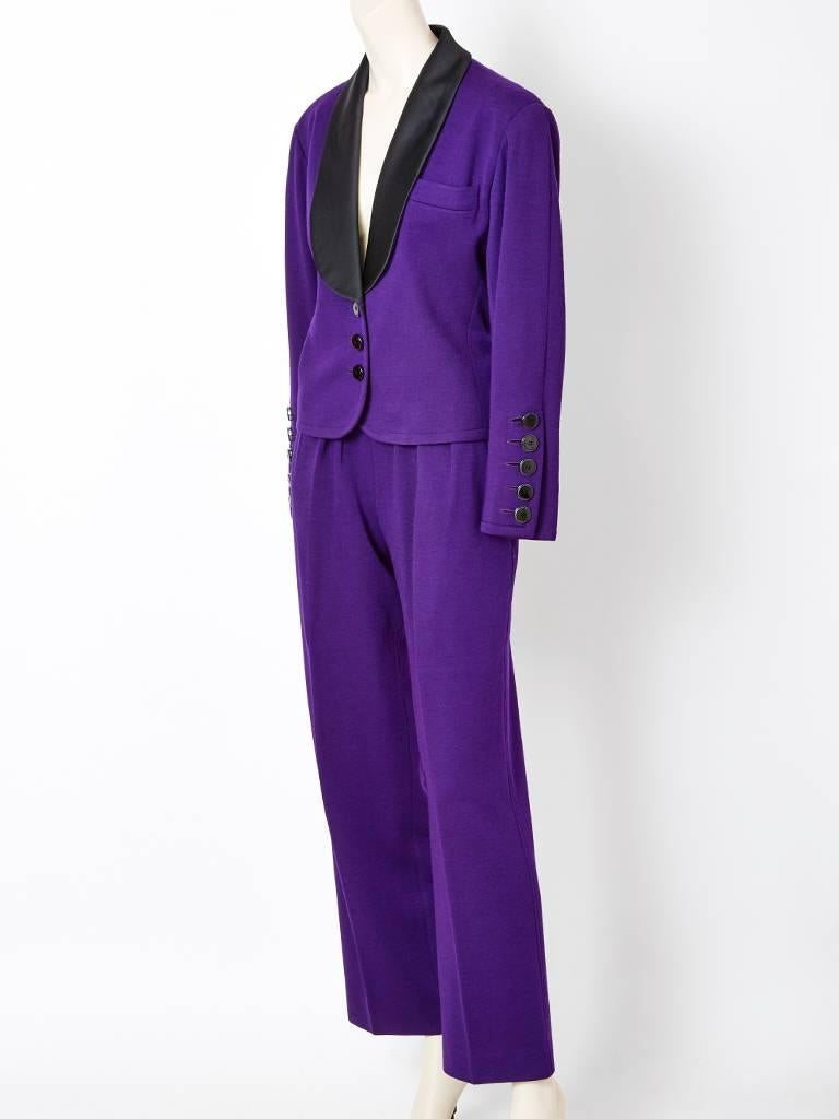 Yves Saint Laurent, purple double knit wool, tuxedo, pantsuit, having a black silk taffeta shawl collar. Jacket has a single button closure with a fitted silhouette. Pant has a straight leg with fly front .