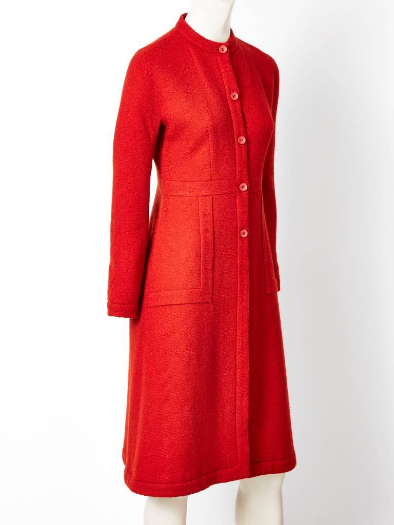 Sybilla, tomato red, textured wool, collarless, fitted, princess line, coat having a raglan sleeve and hidden side pockets.