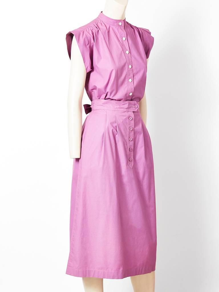 Yves Saint Laurent, lavender, cotton 2 piece day ensemble, having a top with caped sleeves, a Mandarin collar with front button closures. Top can be worn tucked inside skirt or out like a tunic. ( it has side slits). Skirt has trouser-like closure