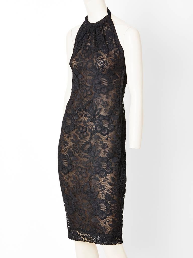 Yves Saint Laurent Couture, black lace, fitted dress having a nude chiffon underpinning, a halter cut 
neckline and shoulder treatment and open back. C. 1990's