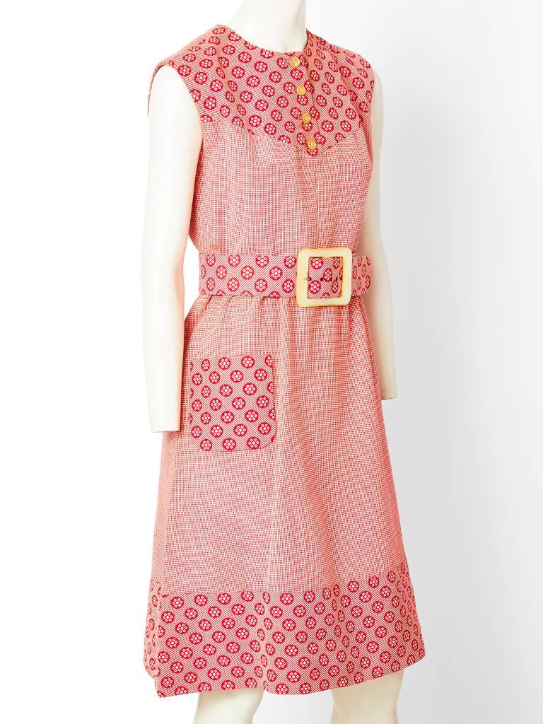 Valentino boutique, red and white cotton matelasse mixed patterns, sleeveless, day dress., having a yoke, belt with a mother of pearl buckle, a single pocket and a band at the hem. C. 1970's.