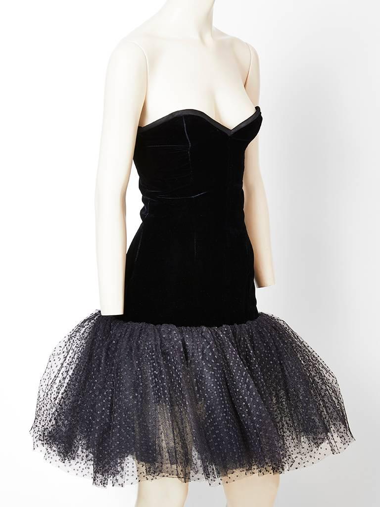 Yves Saint Laurent, Rive Gauche, fitted, strapless cocktail dress, having a velvet bodice and a tier of layered point d' esprit tulle, that starts at the lower thigh and ends above the knee.