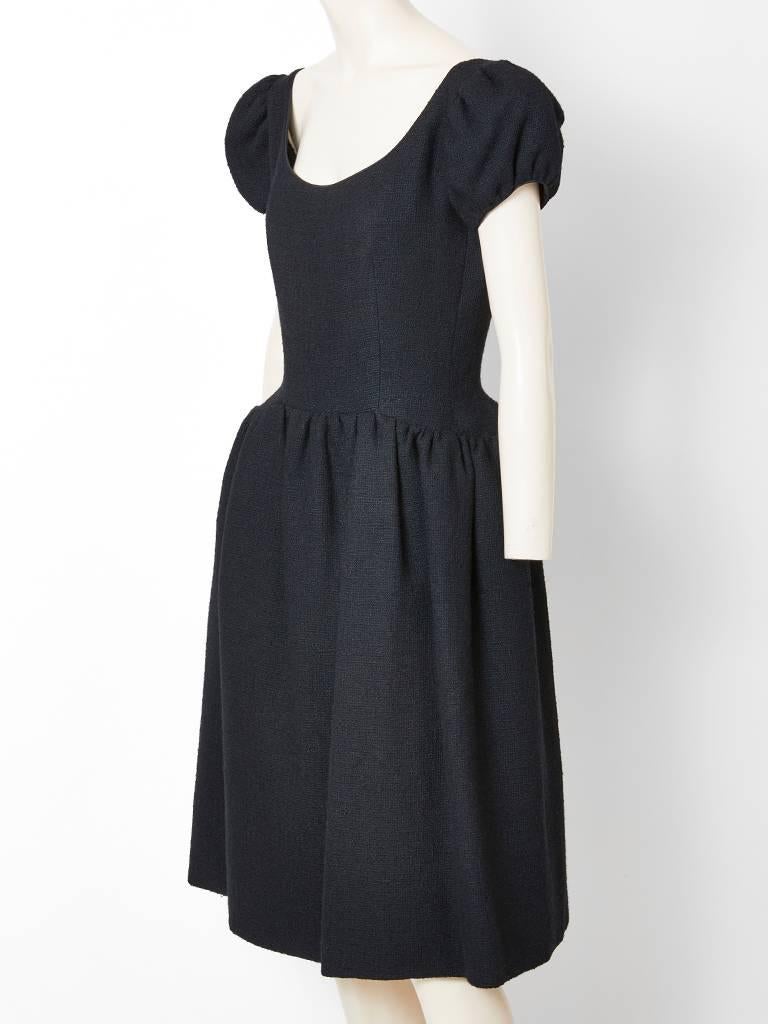 Norman Norell, black, wool boucle, day dress, having a scoop neckline, short puff sleeves, a fitted princess line bodice and a slightly dropped waist.