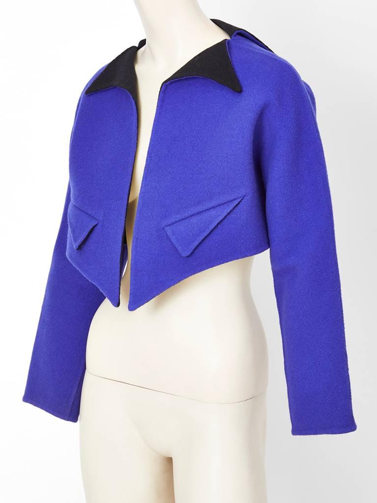 Geoffrey Beene two tone double face wool cropped jacket having geometric details. Exterior of the jacket is a purpleish blue and the interior is black. Jacket has a pointed  triangular collar, similar shaped decorative pockets and a pointed front