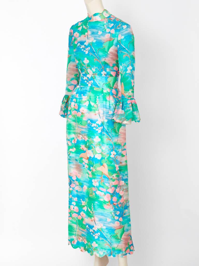 Tina Leser, cherry blossom print, silk and and silk chiffon maxi dress having a high neckline, semi fitted bodice, long sleeves with a gathered scalloped edge detail. Long skirt is gathered with a scalloped hem. Lovely shades of aqua ,blues, green