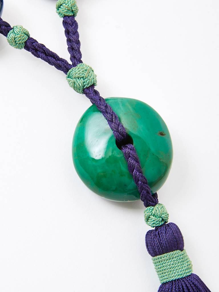 Yves Saint Laurent, Rive Gauche, Chinese inspired pendent in shades of blues and jade green. Necklace, having large lucite beads, strung on a deep blue braided cord with a tassel. C. 1980's.