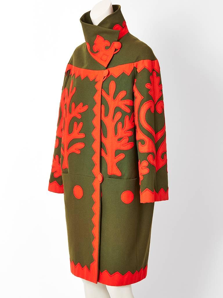 Christian Lacroix, chocolate brown wool coat having orange tone,  Matisse cutouts inspired wool applique detail. Very graphic. Silhouette is inspired from late Edwardian style ( C. 1918). Straight body with a funnel neck collar and off center