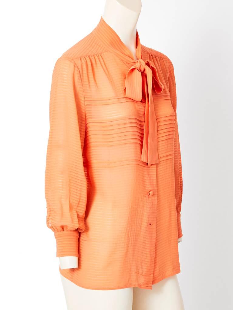 Vintage, Chanel, peach tone, silk georgette blouse having a slim tie at the neck , soft gathering at the front and back yoke, and horizontal pleating detail in the front. C. early 80's.