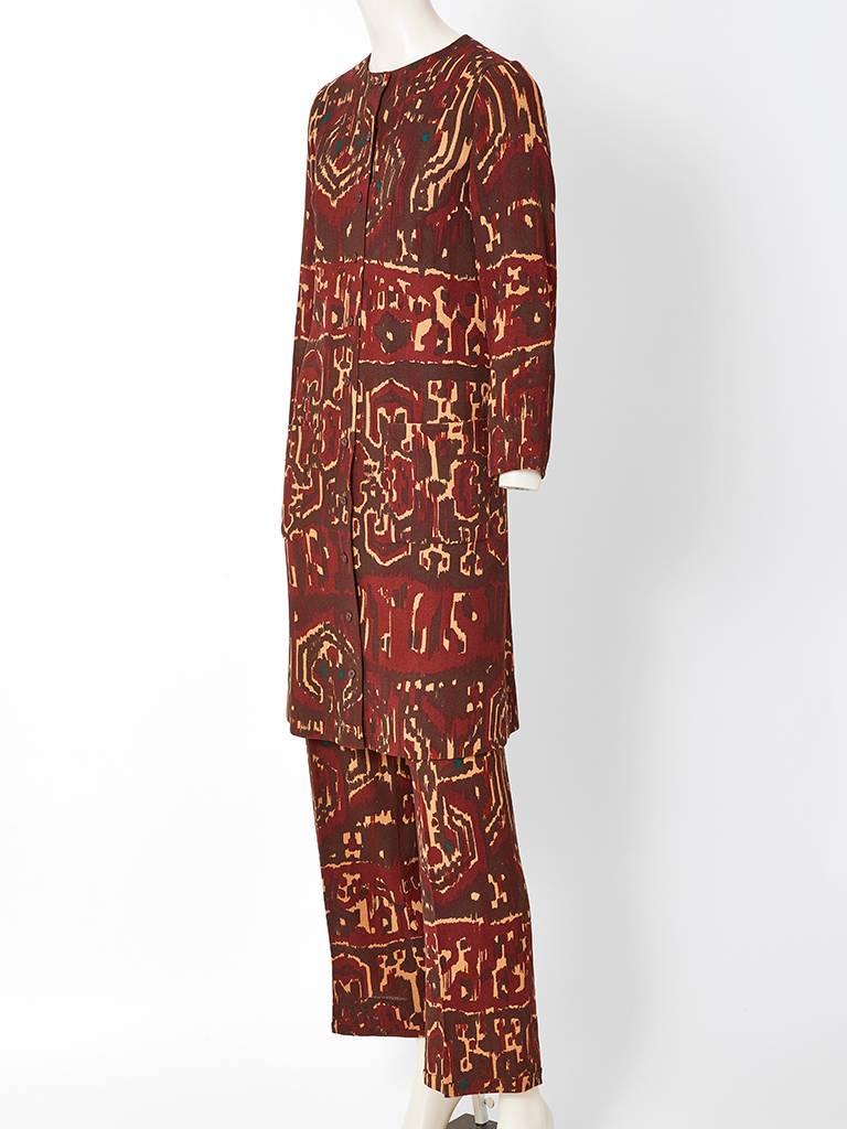 Yves Saint Laurent, Rive Gauche, African inspired,  earth tones, wool crepe, tunic and pant ensemble c. 1970's. Collarless long jacket/tunic has a narrow silhouette with high arm holes creating a slim affect. Trouser is straight legged that widen