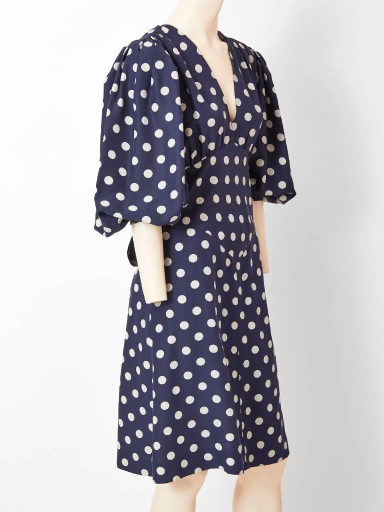 Yves Saint Laurent, Rive Gauche, navy and pale grey, 1940's inspired , silk polka dot dress, having a deep V neck,  3/4 puff sleeves, and a fitted bodice. There is gentle gathering at the bust . Fitted bodice can be adjusted by its self tie that