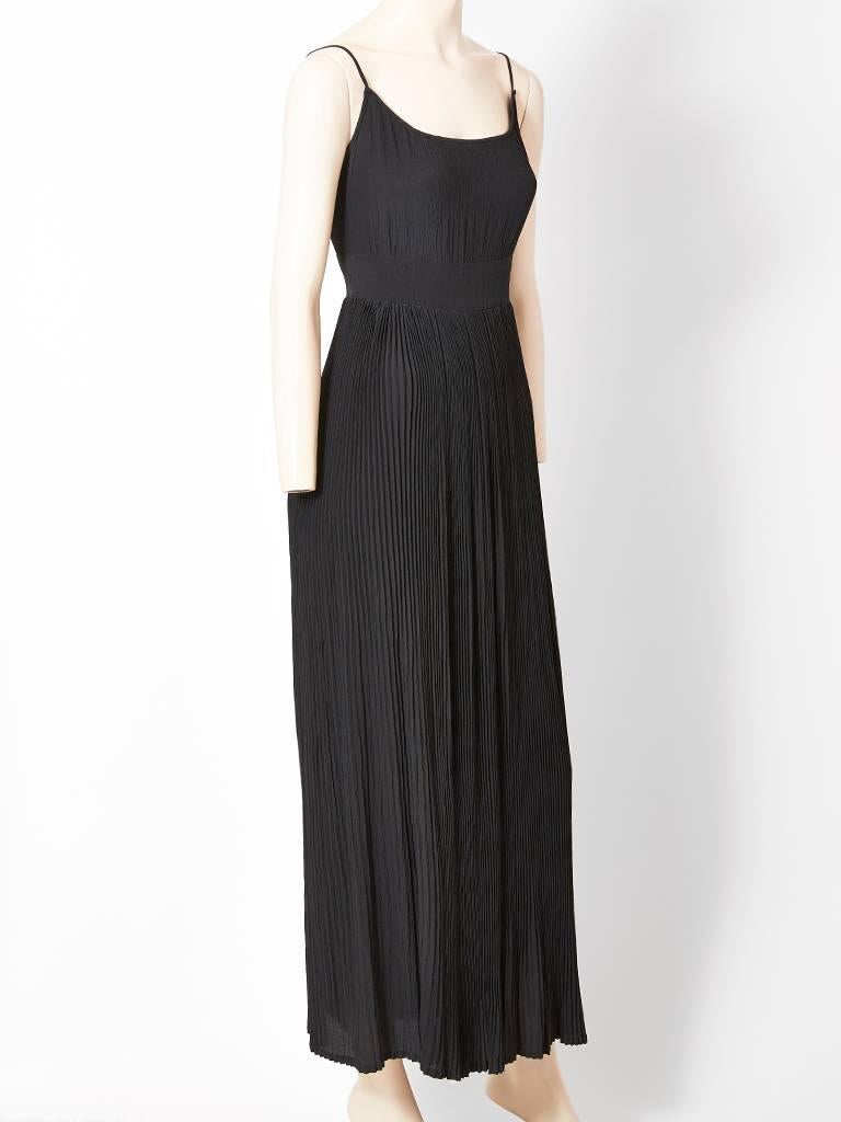 Chanel Créations ( pre Lagerfeld) black simple, Grecian inspired gown, having a scoop neckline with spaghetti straps with a subtle crinkle crepe bodice. The dress has a self attached wide waistband with a plissé skirt. Side zipper closure. C. 1970's