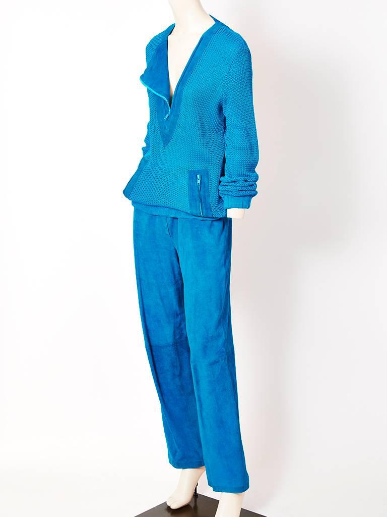 Gucci, turquoise, suede and cotton knit pant ensemble having a cotton open knit, long sleeve top with a suede triangle insert at the neckline that zips open. Suede diagonally placed pockets also have zipper detail. Pants are suede with an elastic