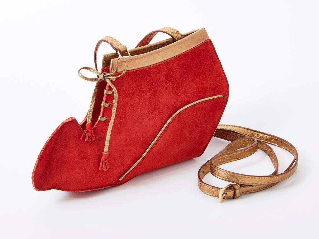 Ferragamo, tomato red suede, boot profile, shoulder bag with gold leather detail.
