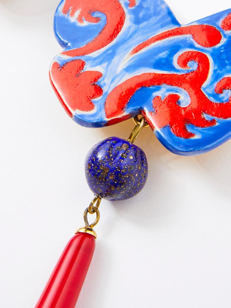Yves Saint Laurent, RIve Gauche, Chinese inspired drop, clip on earrings, having a large ceramic, butterfly motif clip in reds and blue. A round speckled blue glass bead is attached along  with a red glass long drop.  Signed 