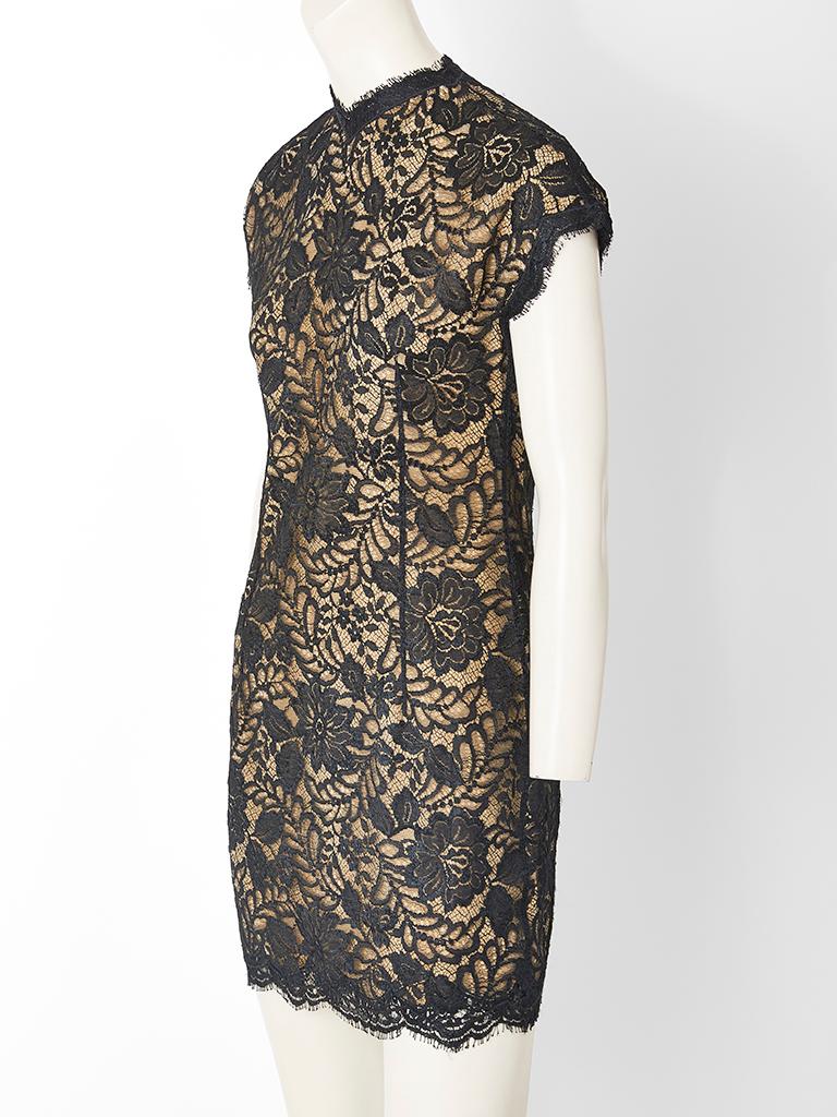 Geoffrey Beene fitted, black, fine lace, cocktail dress having a cap sleeve and a high V neckline. Dress is lined in a nude tone silk.