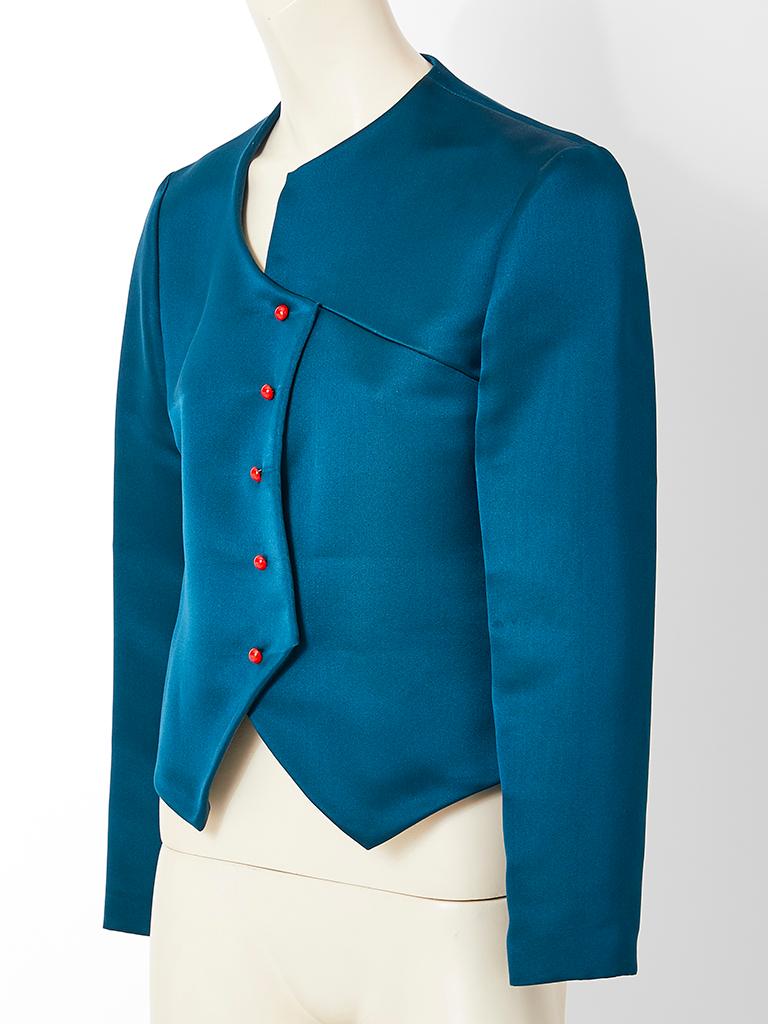 Geoffrey Beene, duchess satin, Spencer style dinner jacket in a teal blue tone. Jacket has architectural details, ( a Beene Signature) having an asymmetric closure with a combination of curves and points.
Red button closures are unexpected but well