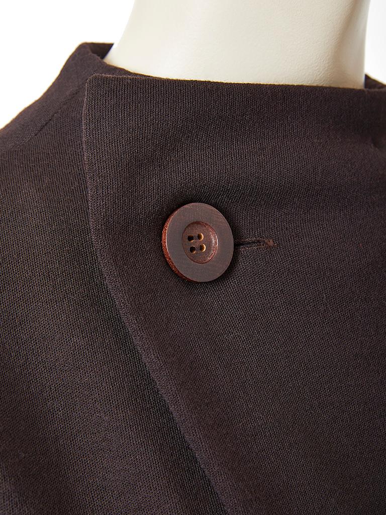 Geoffrey Beene, wool knit, fitted day dress, having cap sleeves and an
off center, curved closing at the neckline, embellished by a singular large wood button closure.