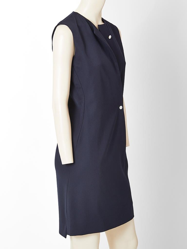 Geoffrey Beene , minimal,  navy wool, sleeveless, day dress having no collar and an off center curved closure fastened by two buttons.