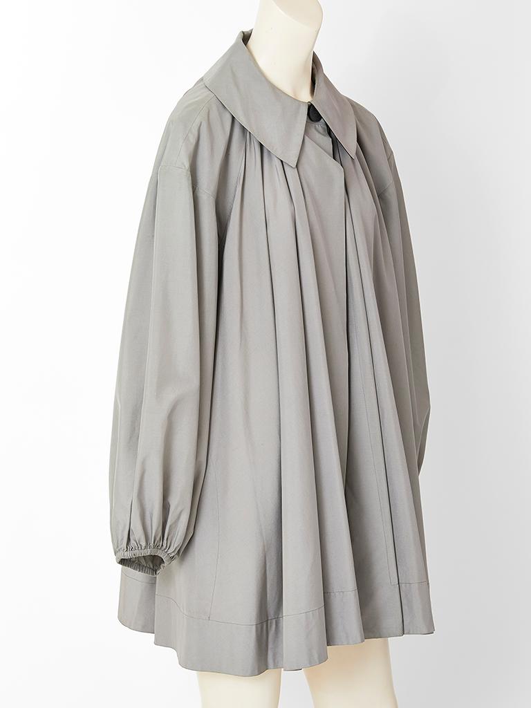 Yves Saint Laurent, grey, silk taffeta swing jacket, having a pointed collar that fastens at the neck. Balloon sleeves, have elastic at the wrist. Jacket gathers all around at the shoulder, front and back creating volume and movement.