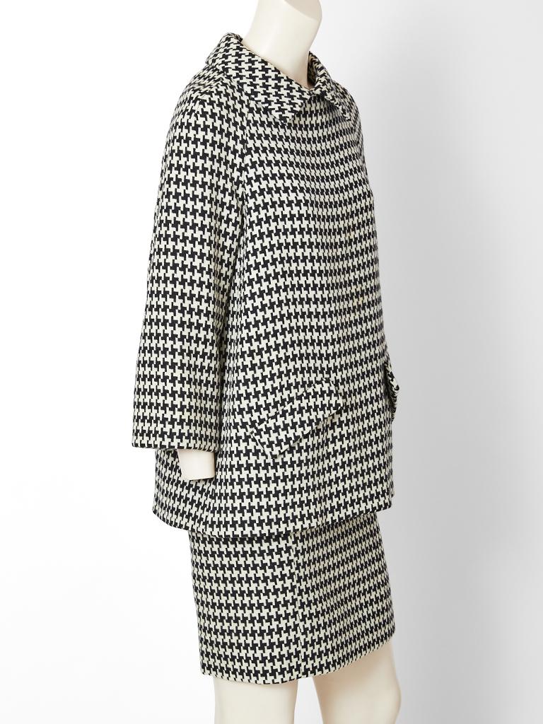 Geoffrey Beene, black and white, large scale, wool, houndstooth pattern, tunic and skirt ensemble. Tunic has an A line silhouette, having a pointed collar, lowly placed flap pockets and center back button closures. Matching pencil skirt ends above