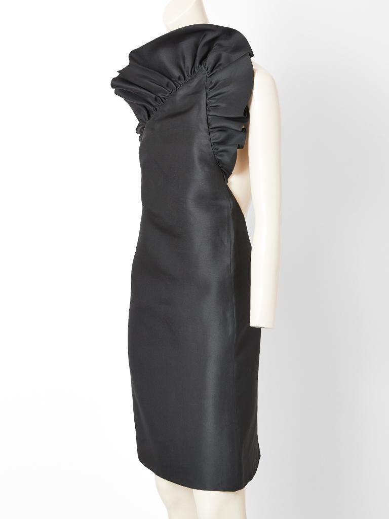 Tom Ford for Gucci, abito da cocktail monospalla in gazar di seta nero con una silhouette ad A e un bordo increspato sulla parte superiore e sotto il braccio del vestito. La schiena è aperta a forma di U profonda fino alla vita.
C'è un unico