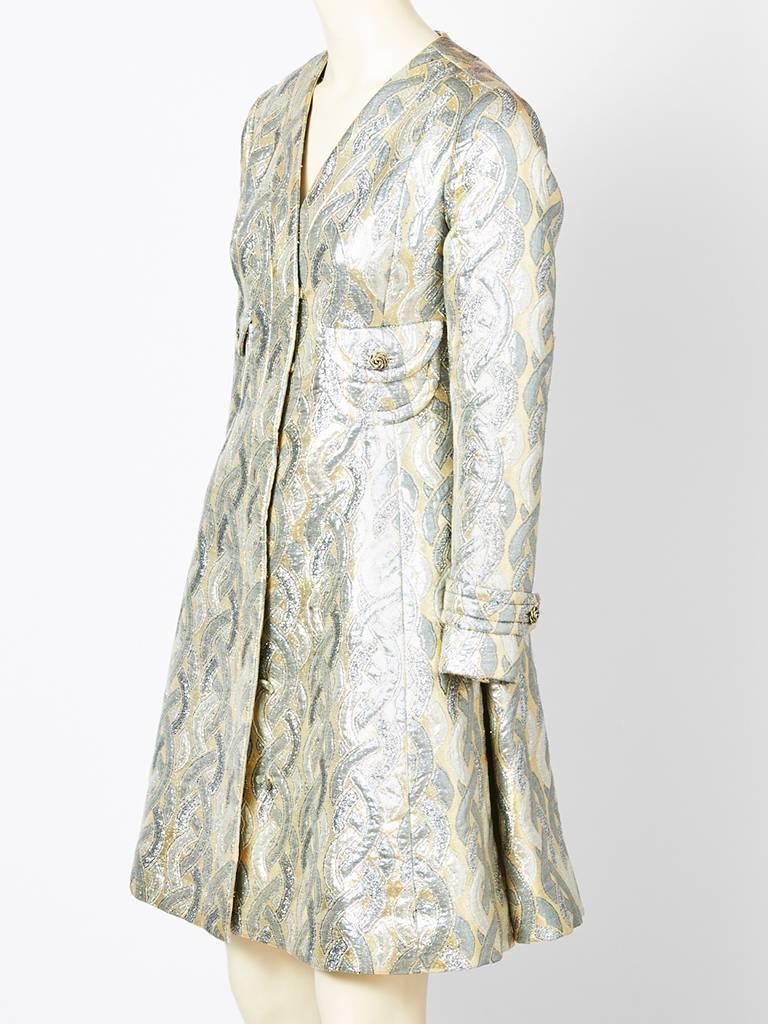 Galanos, sliver brocade, coat dress, having an A line shape with a v neckline, 
breast pocket detail and hidden button closures.