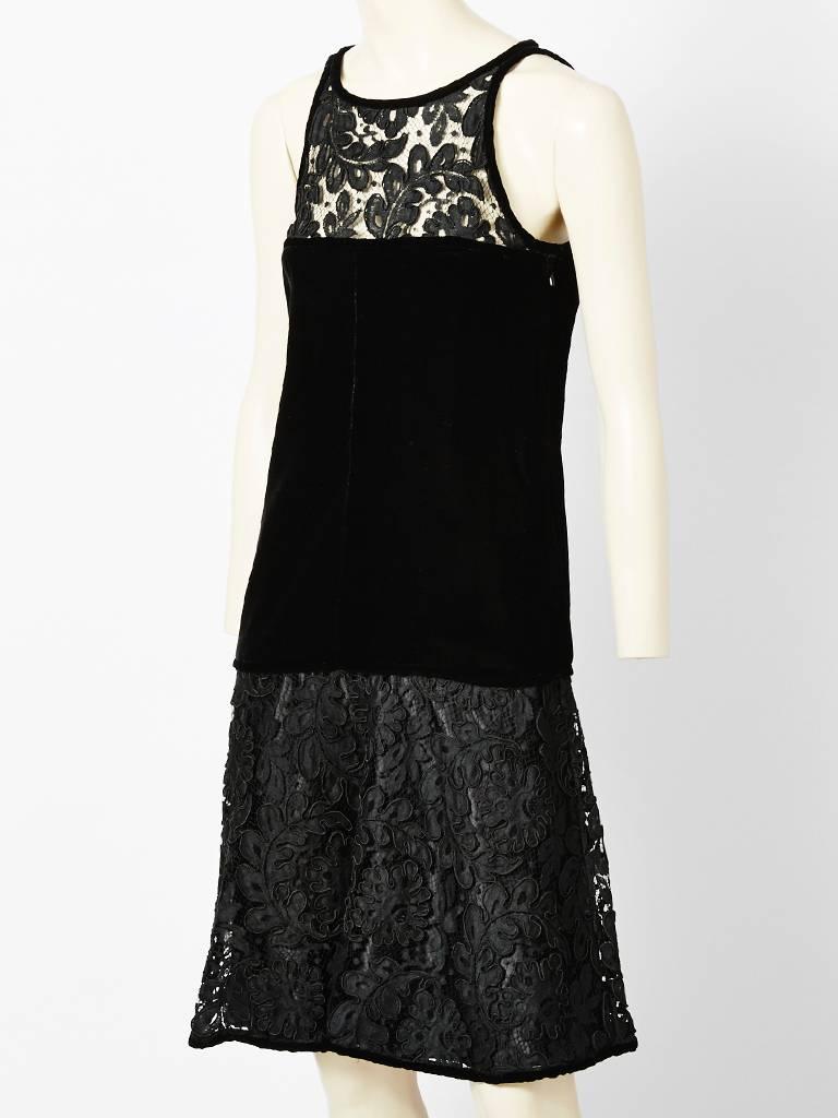 Yves Saint Laurent, black, velvet and lace cocktail dress. Collarless, sleeveless,
with a lace bodice ending above the bust. The middle section is velvet, fitted at the bodice, waist, and hip, ending at the upper thigh. From the upper thigh to the