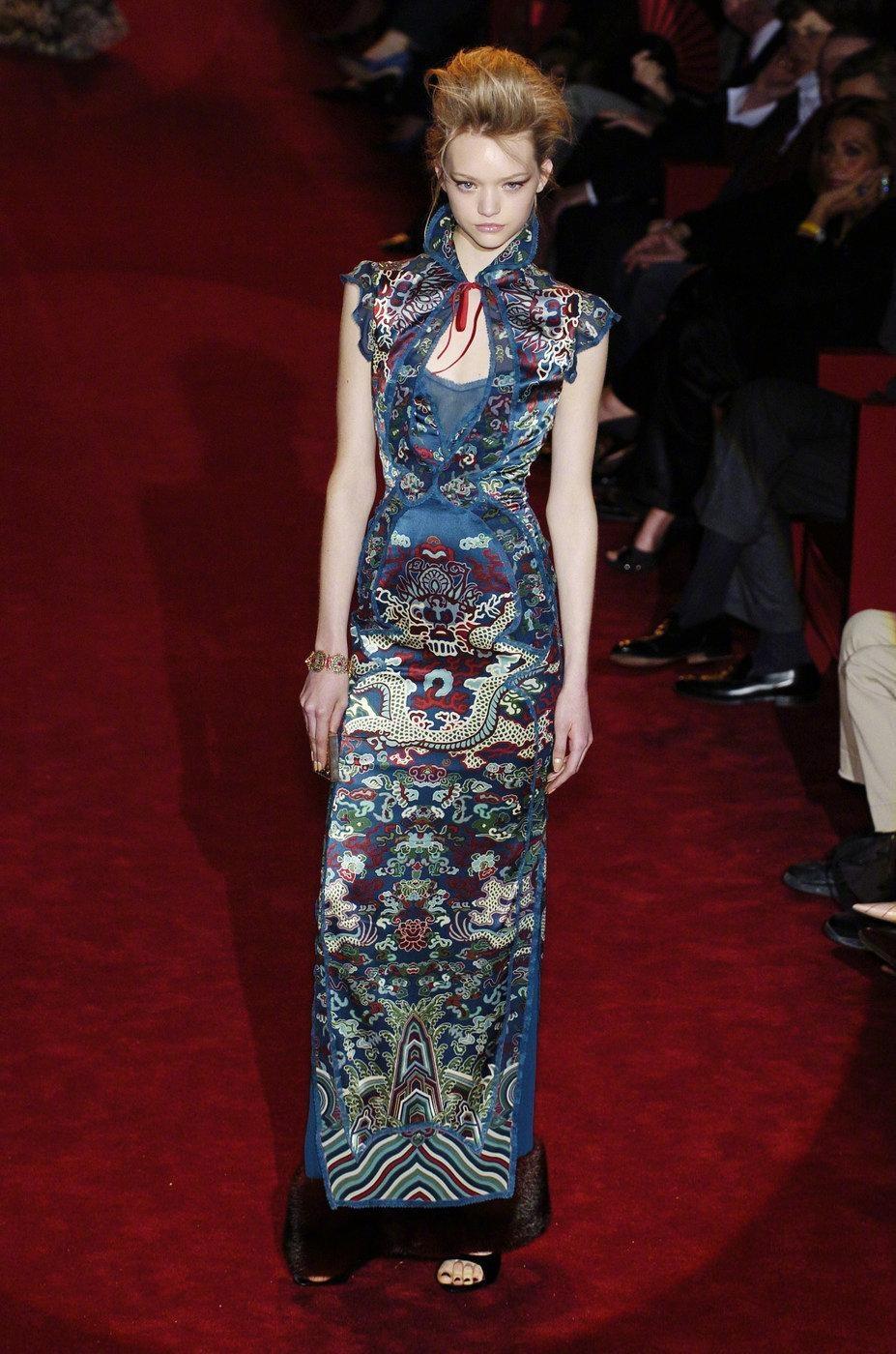 Cette robe est une pièce étonnante, au design complexe, inspirée par les motifs et le symbolisme traditionnels de l'Orient. La silhouette ajustée est ornée de motifs vibrants et ornés de deux dragons mythiques tissés dans des tons or et rouge,
