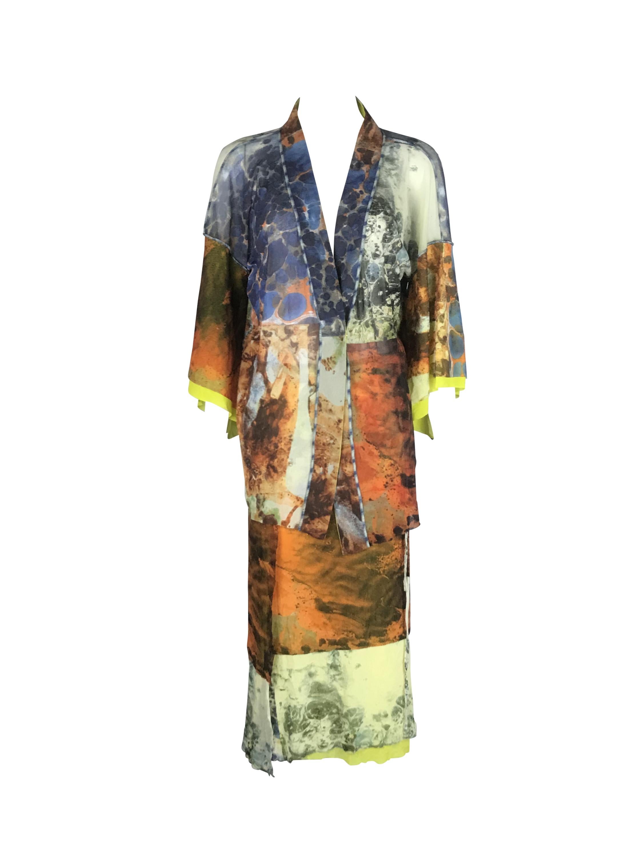 Il set di kimono in rete di Jean Paul Gaultier primavera-estate 1999 Abstract Bacteria è caratterizzato da un sorprendente mix di arte e moda, con una stampa astratta marmorizzata su una rete trasparente e strutturata. L'outfit comprende una giacca