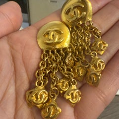 Boucles d'oreilles à clip CHANEL vintage en or avec logos CC en chaîne pendante
