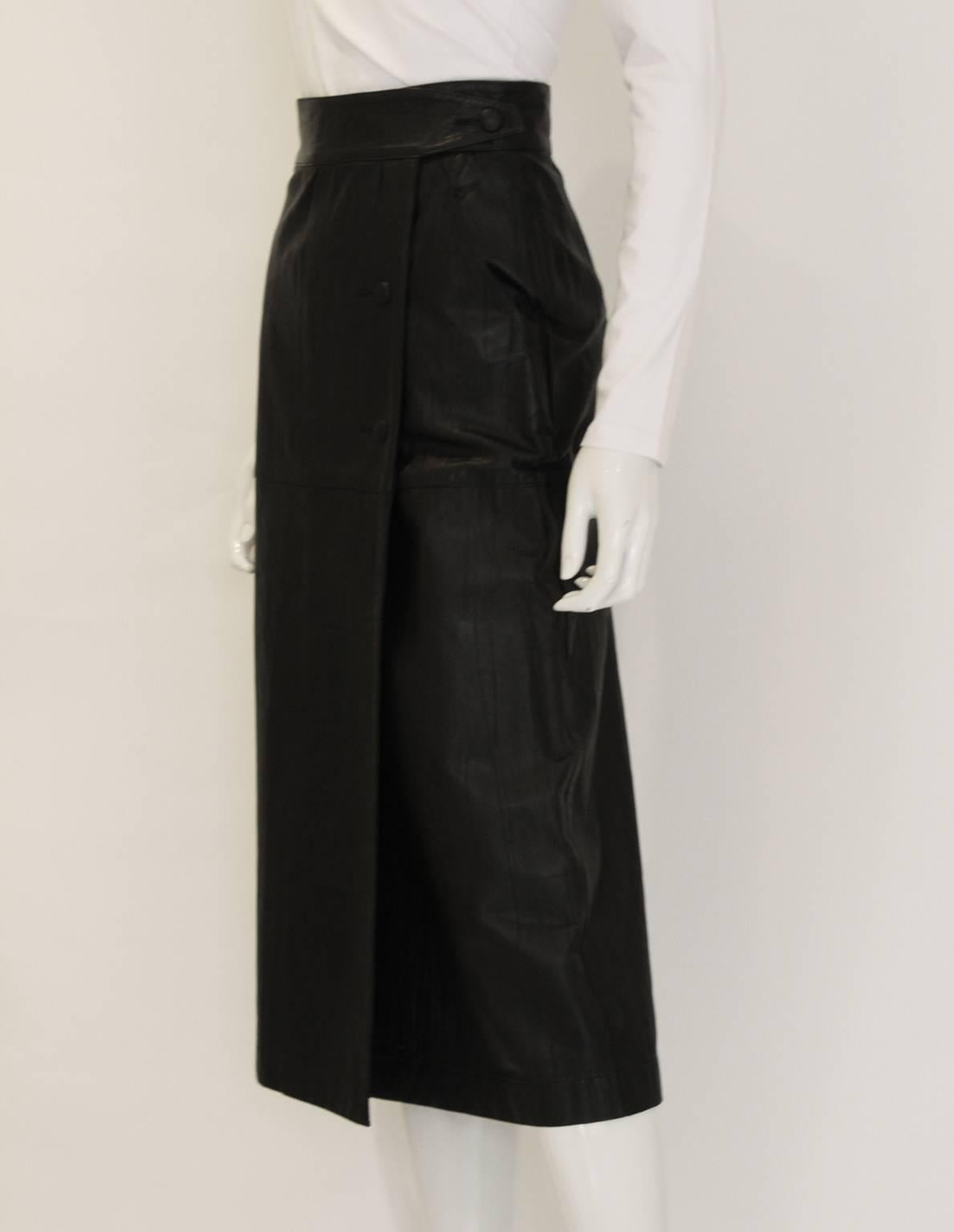 This skirt is a really cool statement piece by Japanese designer, Issey Miyake. It's made of a textured, almost pleated, black leather and is a wrap over style. The waistband also has a wrap over feature and here are two buttons holding the skirt in