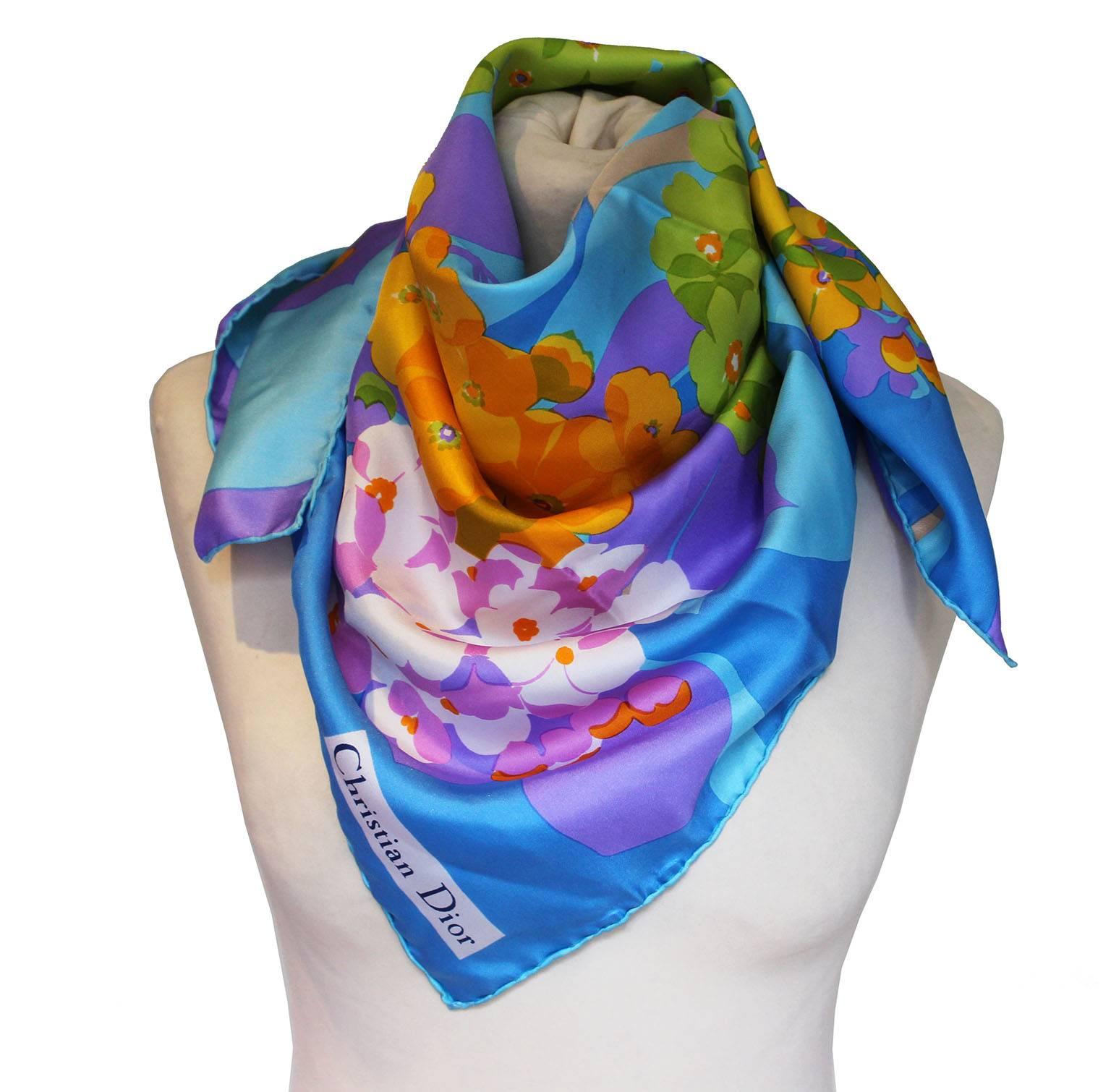 This is a wonderful scarf for Spring, with a tulip and primrose design.
The colours are a super mix of blue, orange, purple, white and green, and it has Christian Dior written in one corner.