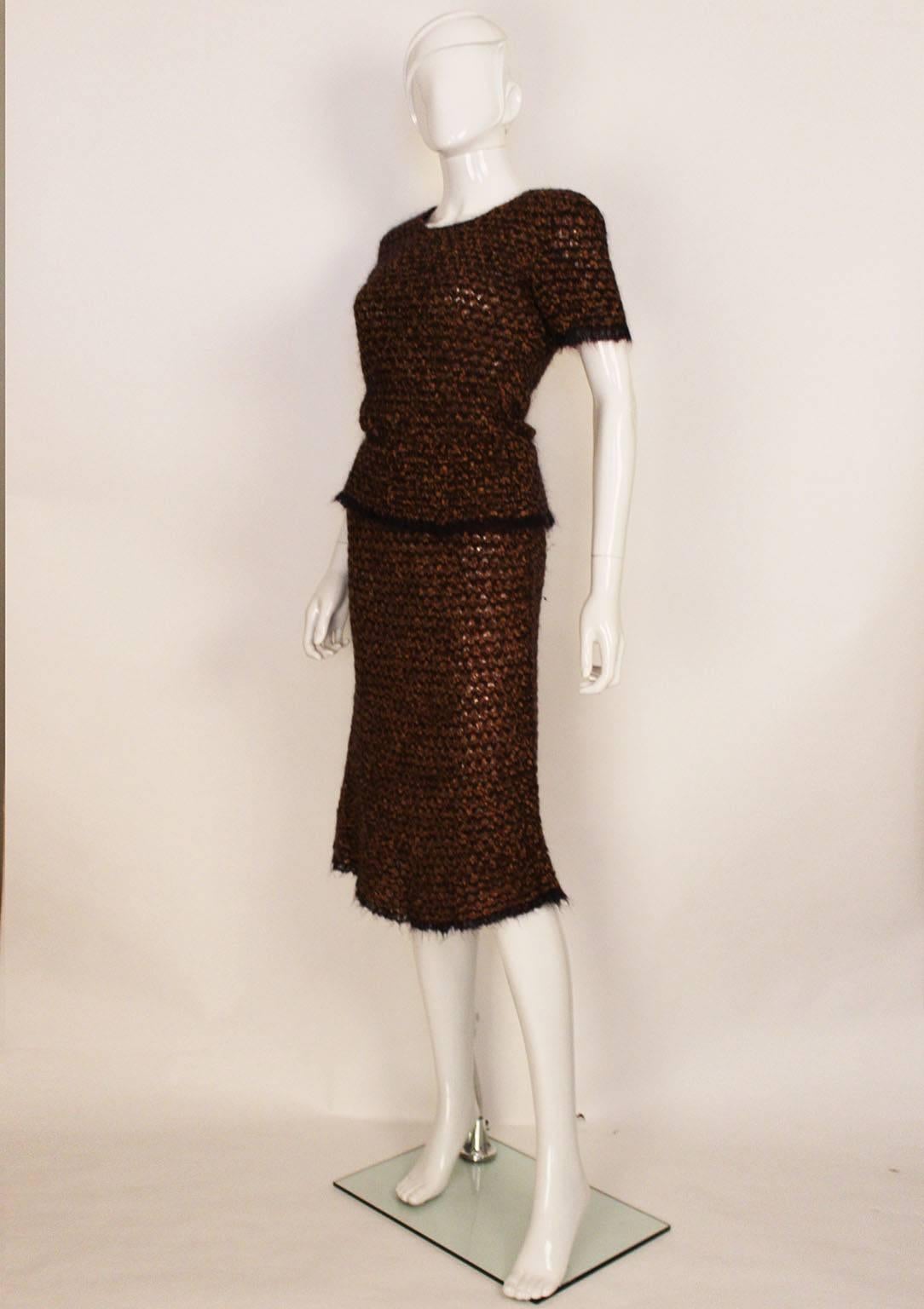 A charming and chic knitted two piece from Chanel . In a wonderful colour combination of chestnut brown, tan and blue. The fabric is a wool,mohair, rayon and nylon mix. It was made in 98A, M8048. The top is 't shirt' shaped , with a subtle Chanel