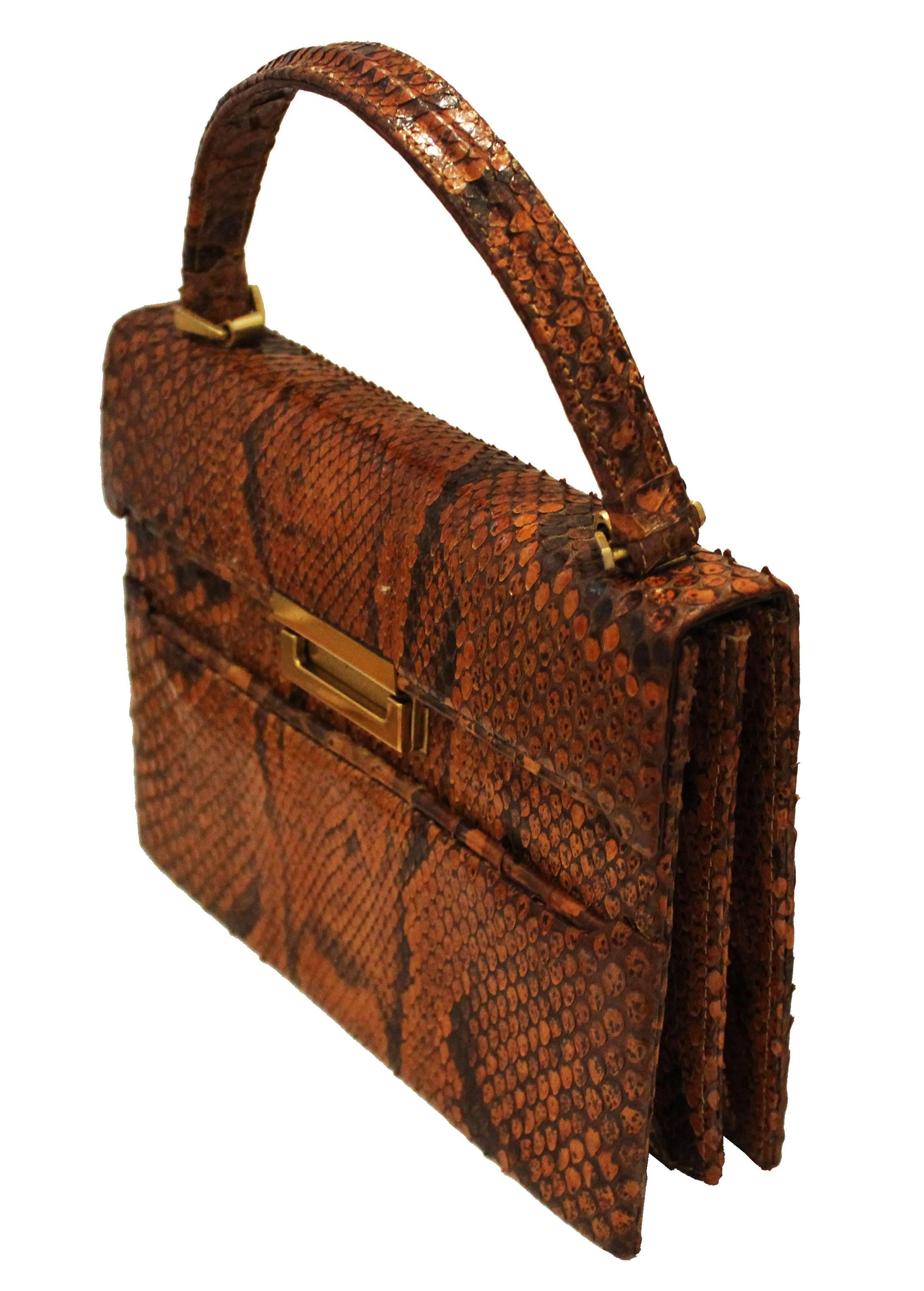 A charming and chic vintage handbag from the 1940s,in tan and dark brown snakeskin. This handbag has a foldover top, and central gilt clasp. There is an external pouch pocket. The interior is leather lined, and has two compartments each with a pouch