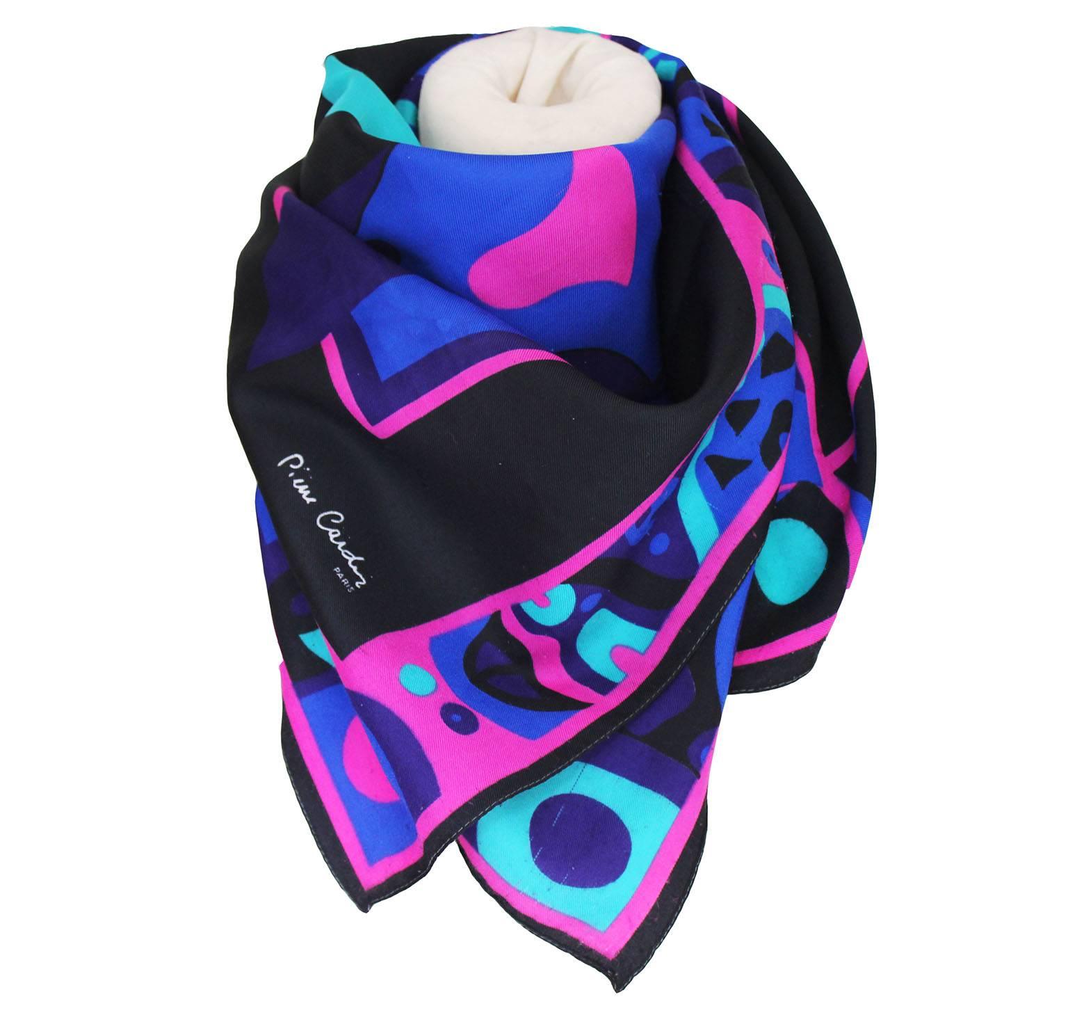 A colourful scarf with an abstract print from Pierre Cardin, Paris. The scarf has a black border, and a design in a combination pink, blue, black, turquoise and mauve.
It is in good, wearable condition, but there are a few small pulls, as seen in