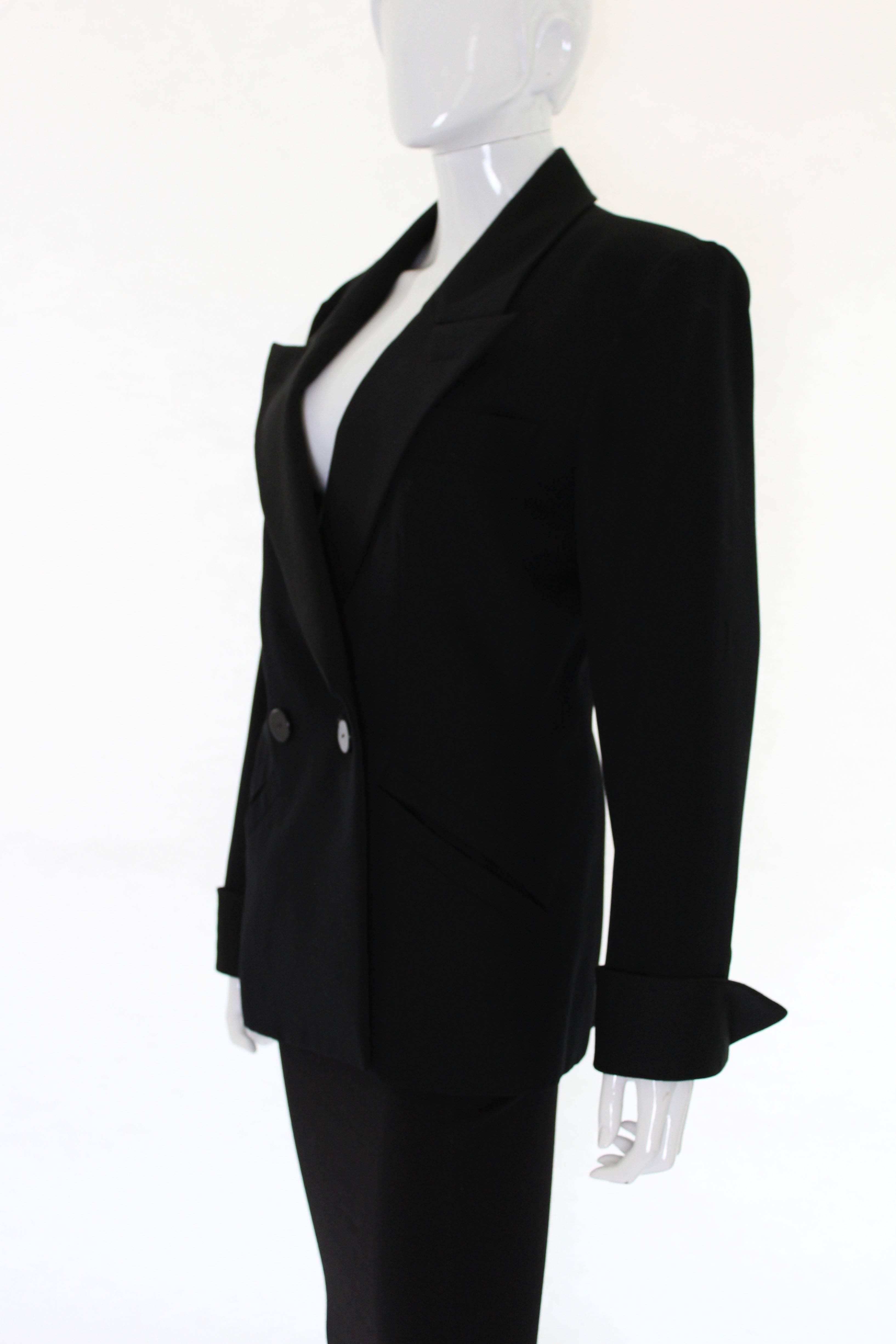 A super smoking jacket by Yves  Saint Laurent, Rive Gauche. In black wool with satin lapels and cuffs , this is a stylish addition to any wardrobe. The jacket has two buttons on the front ,with stylish sloping pockets on either side. There are two