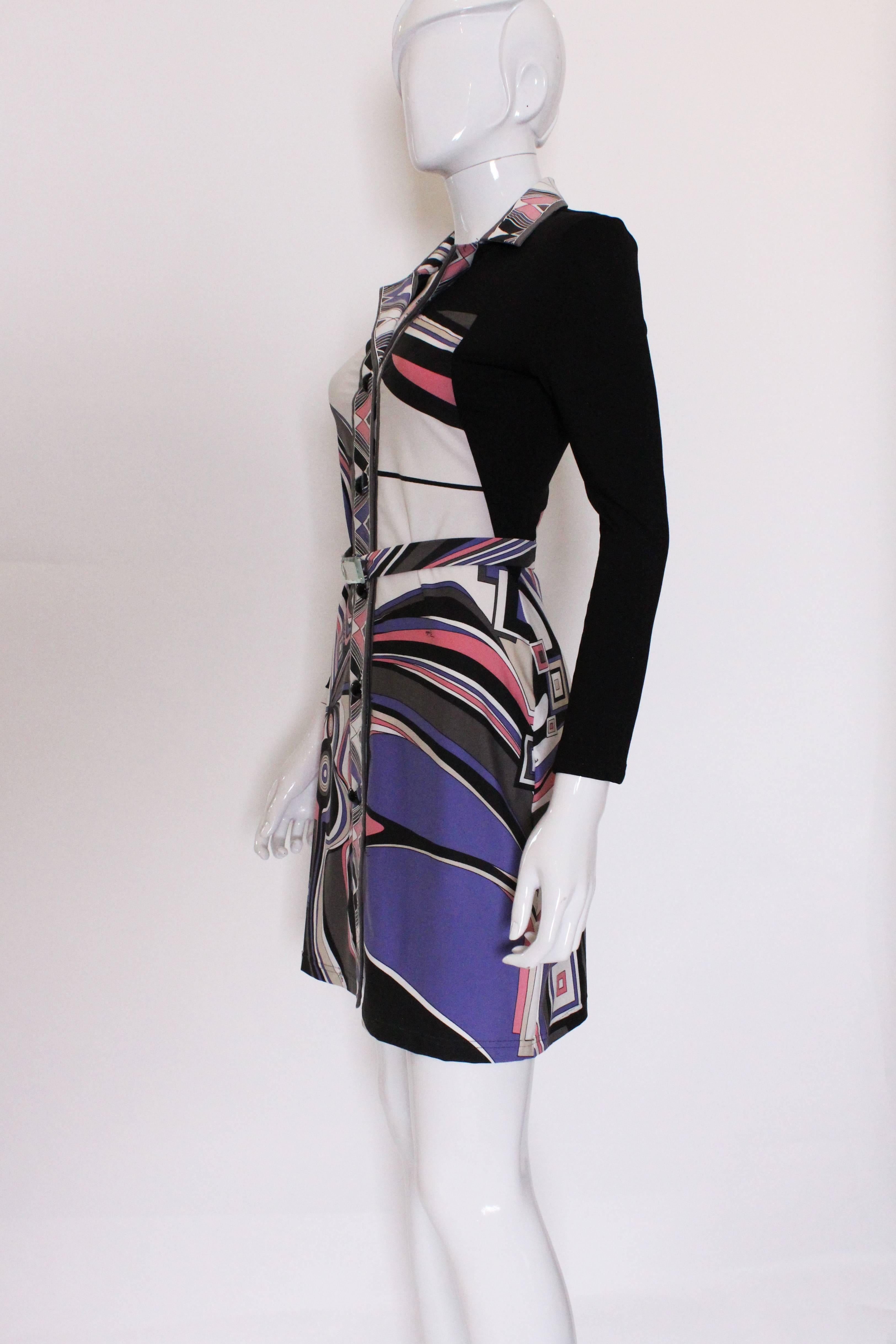
A stylish and easy to wear shirt dress from Italian fashion house , Emilio Pucci.
In their 100% silk jersey, this dress is a great addition to your Spring /Summer wardrobe.It has a black background , with a wonderful colour mix that includes