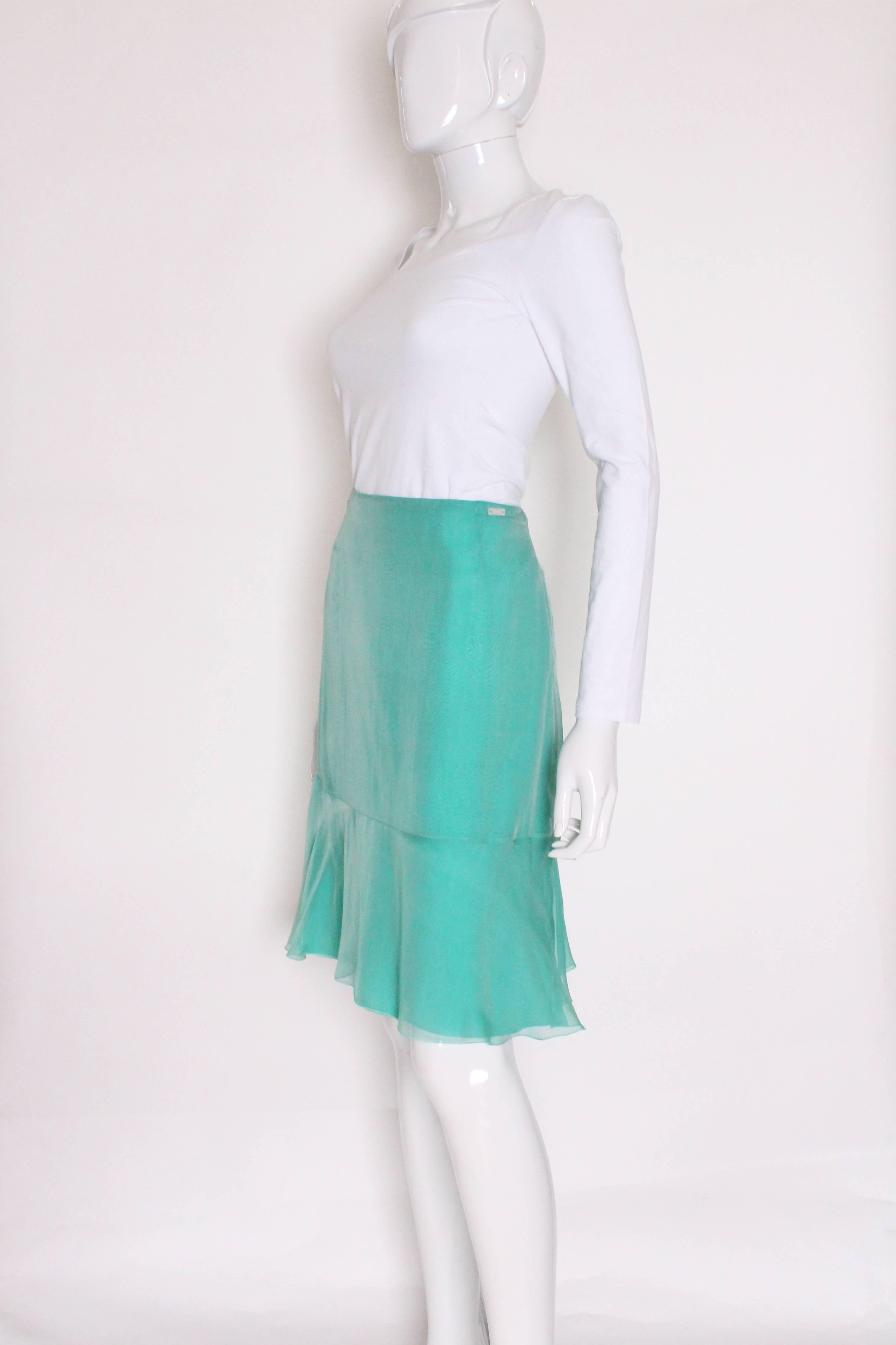 A super seagreen silk chiffon skirt by Chanel.As you would expect from Chanel the silk is of a superior quality , both the outer silk chiffon and the interior silk lining.The shirt has a wide frill ( 8 1/4'' ) at the bottom and a central back zip.