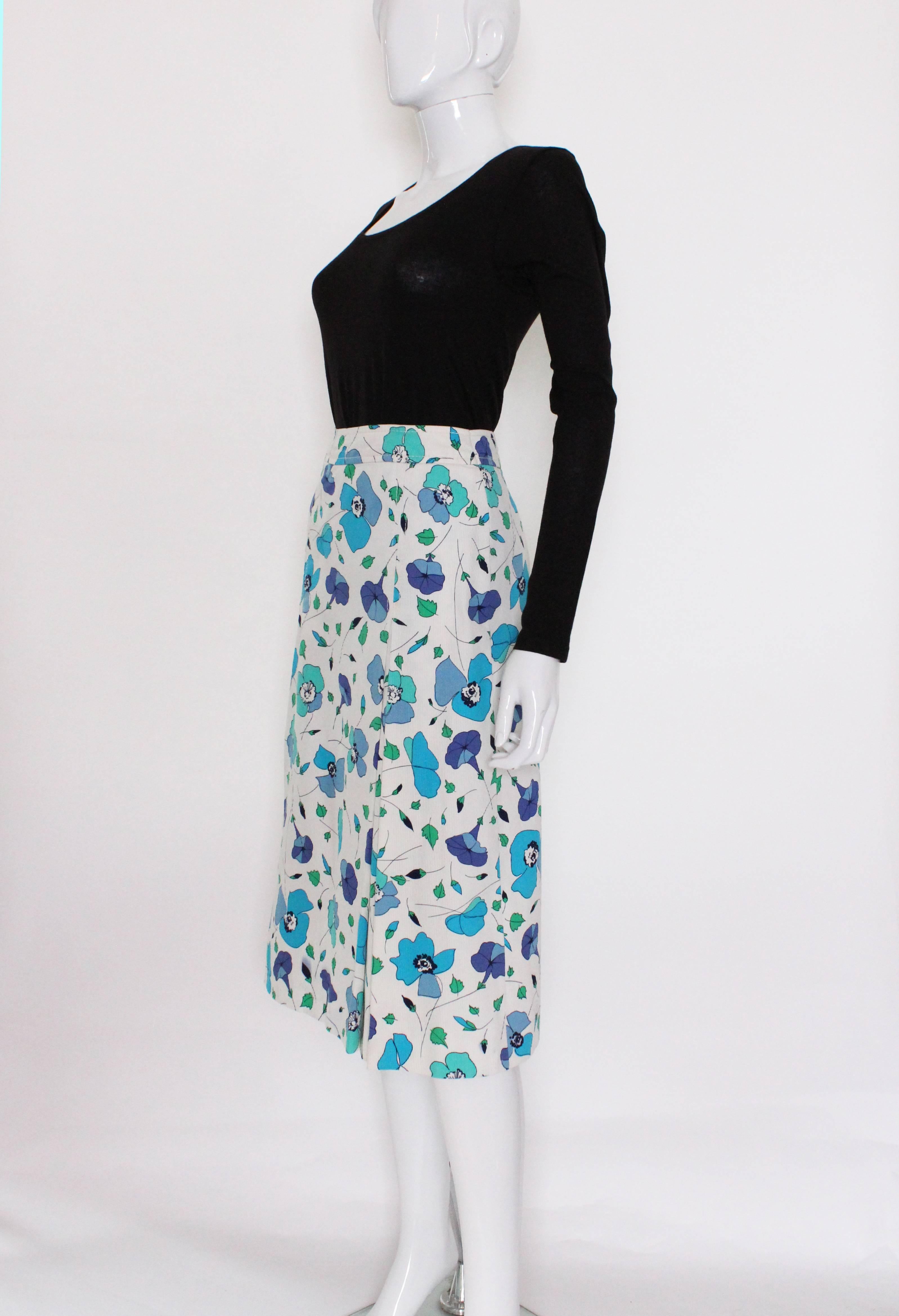 A great skirt for Spring/Summer by French fashion house Celine.
This is a fun , floral printed vintage skirt by Celine.. It has a wonderful floral print on a white ribbed cotton background.The skirt has some unusual pleat detail, with one pleat on