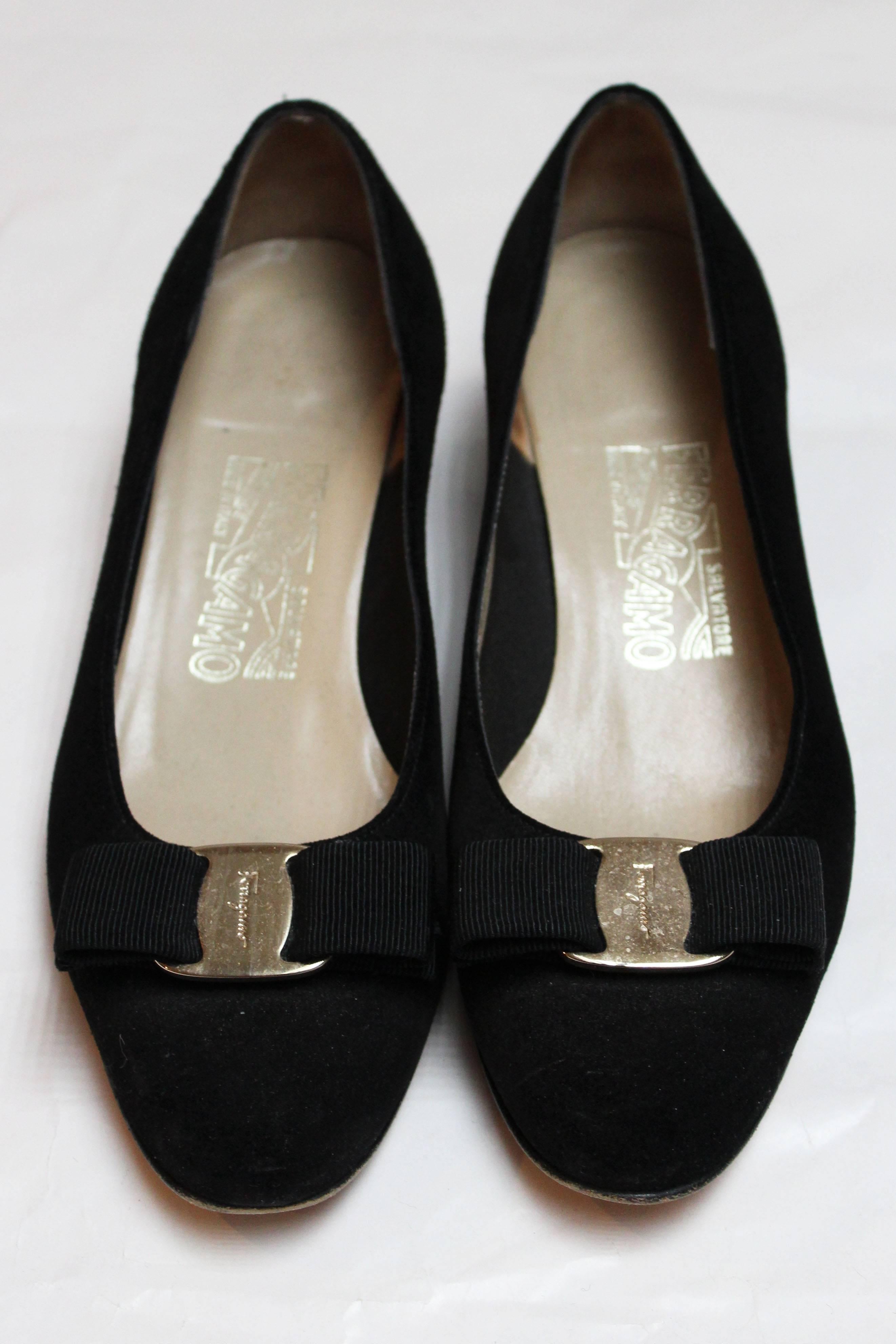 A chic pair of black suede pumps by Salvatore Ferragamo. These shoes have the famous black ribbon bow, and are lined in leather with leather soles.
Size 6B (insole measures  10''), style number DB 79573  338 Heel height  1 1/2''