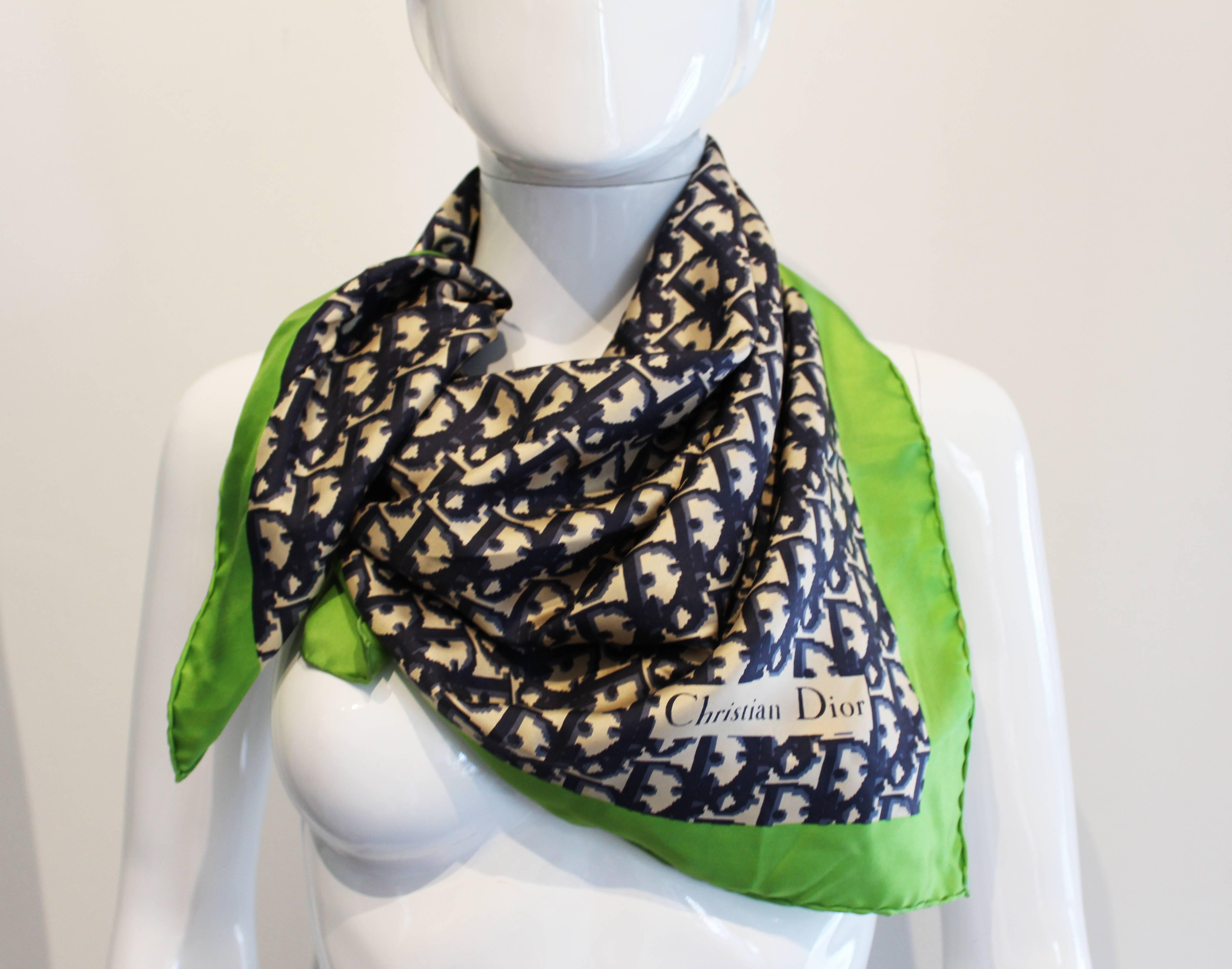 A wonderful scarf for Spring /Summer. This vintage silk scarf has a vibrant green border, with the blue Dior D logo filling the centre  of the scarf on a pale gold coloured background. As you would expect from Dior , the silk is of a superior