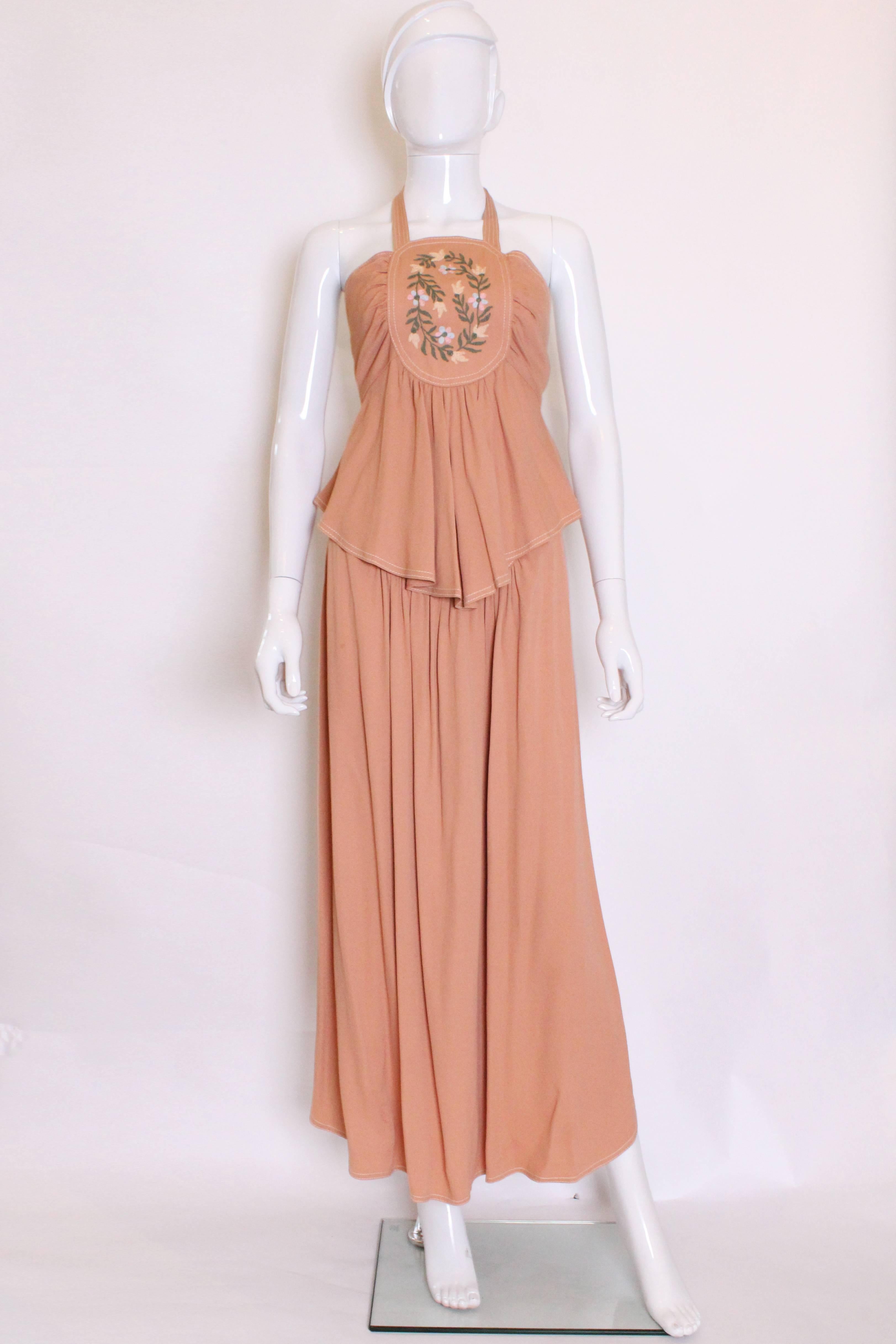 A great outfit by 1970s British designer Bill Gibb. In a peach/buff colour this outfit is a great addition to your summer wardrobe.
The top has a pretty embroidered central panel, in a floral design.There is gathering surrounding the panel ,and a