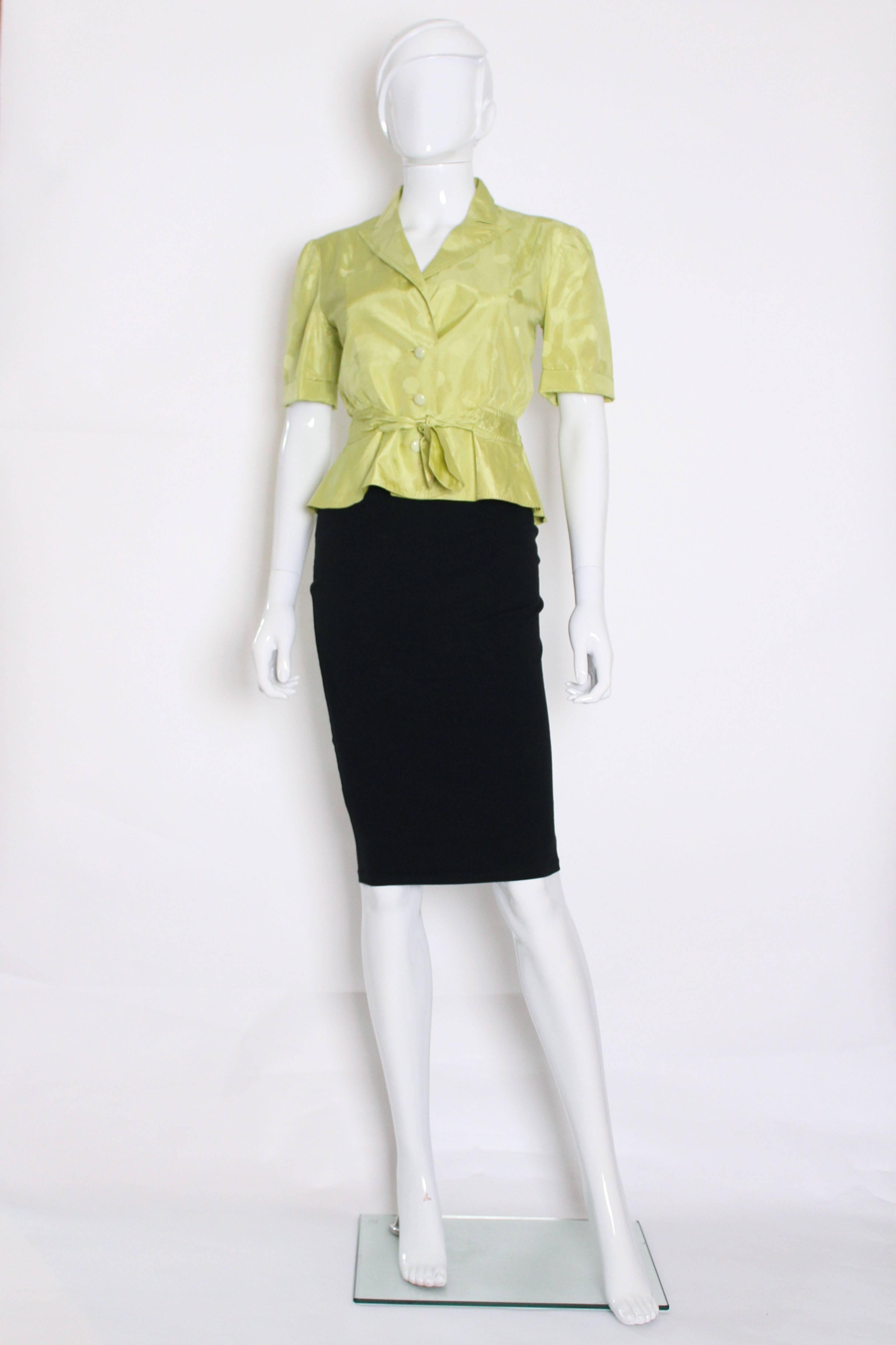 A chic chartreuse colour jacket by Italian fashion house Valentino.
This jacket has spot detail on the fabric. The jacket has short sleeves with turn up cuffs, a breast pocket on the right hand side , three button opening , an attached belt and
