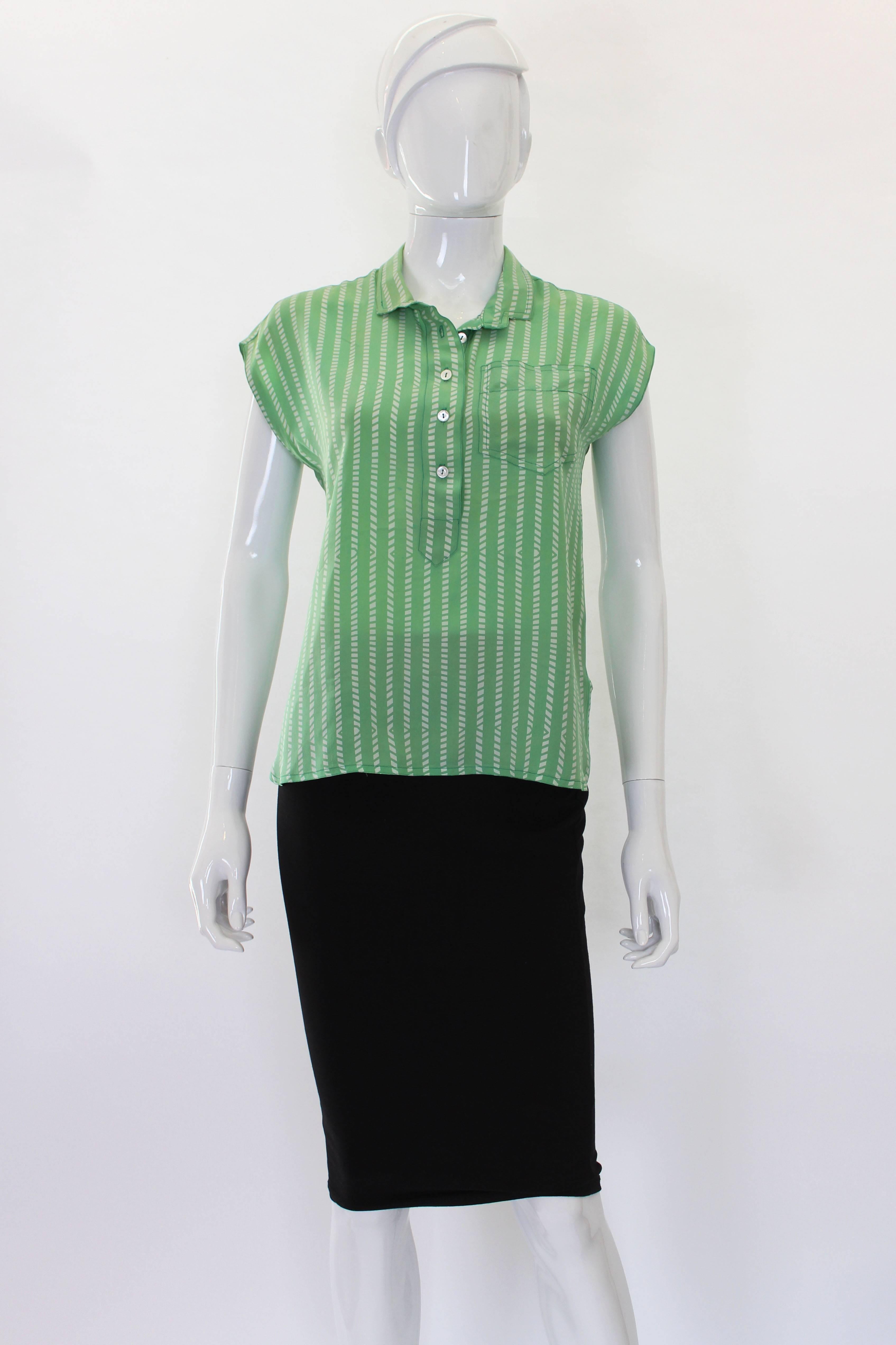 This fine silk blouse is made of a soft apple green with an ivory geometric print. It's a late 80s/early 90s piece in perfect condition. The sleeves give a slight cap over the shoulder without any additional sleeve being added. All 4 button down the
