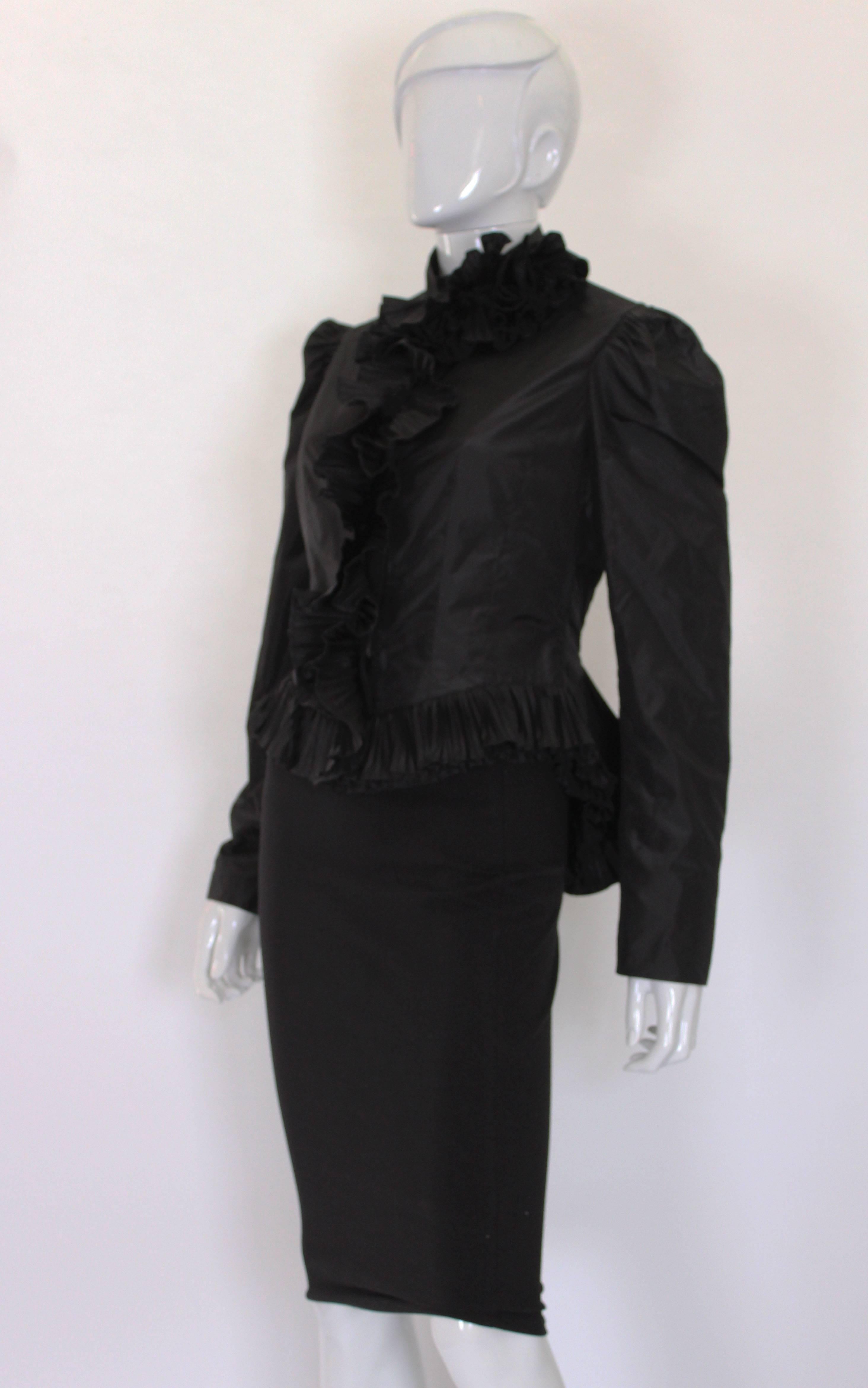 A great and gothic jacket by French designer Yves Saint Laurent, Rive Gauche.
This jacket has gathered shoulders, a nipped in waist and wonderful frilled peplum. The frilled peplum is 3'' .It has a zip opening , with the zip covered by a fold and a