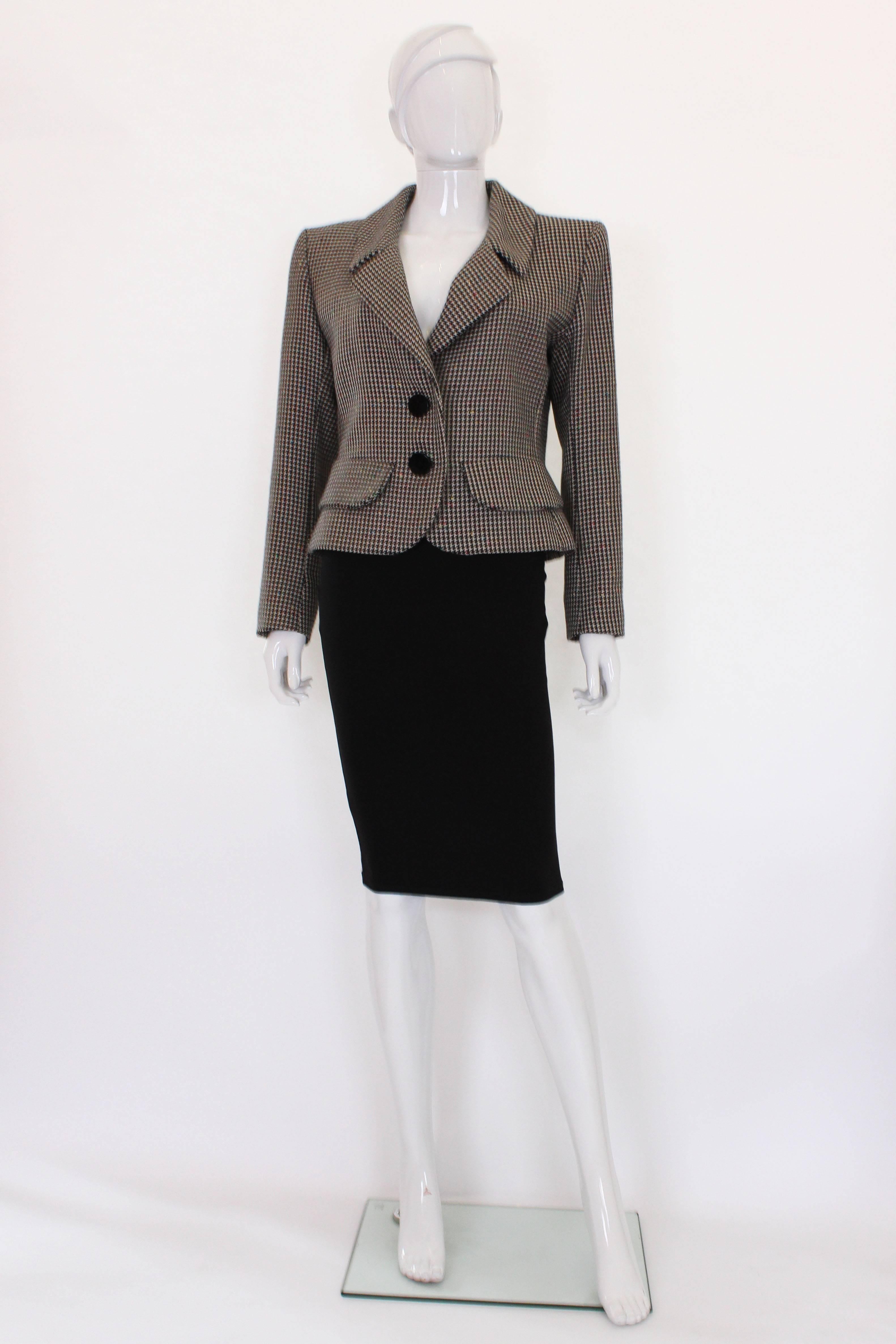 A chic houndstooth blazer by French designer Yves Saint Laurent, Variation range. This jacket has a white background with a black houndstooth design, and spots of colour, red, pink,  yellow green, and blue .It has elegant lapels, 2 false pockets on
