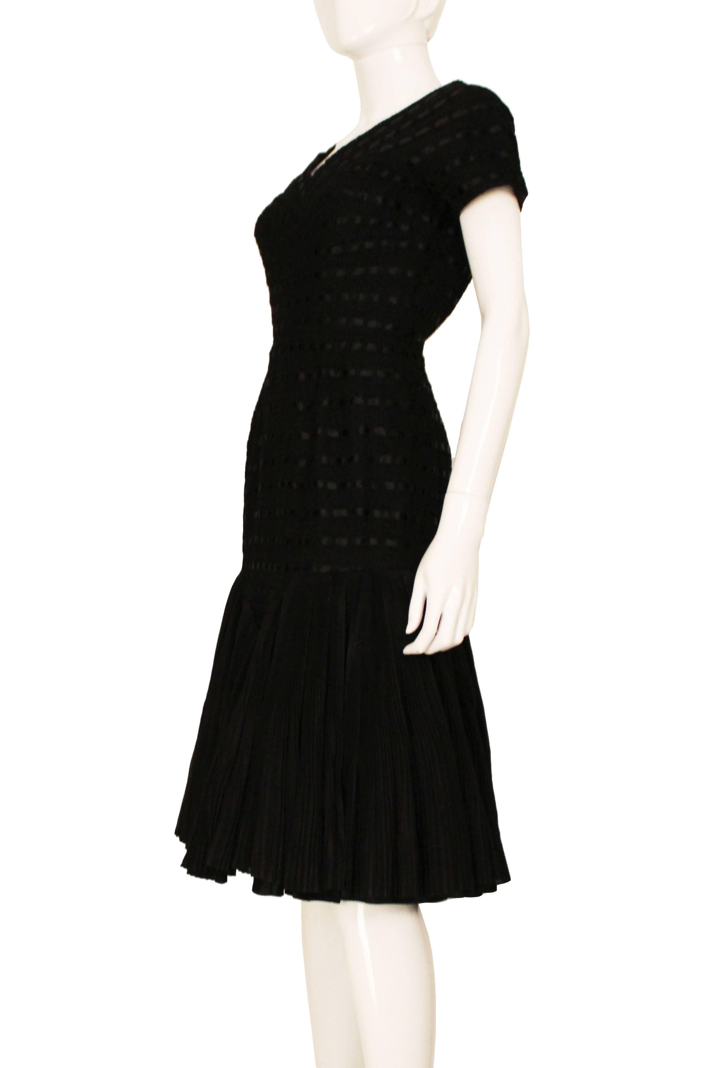 This is a truly stunning 1950s LBD by Irish couturier Sybil Connolly. The main body of the dress is made of a crochet that's then woven with black ribbon. There is so much detail in the fabrics that make it a truly amazing dress. It has a beautiful