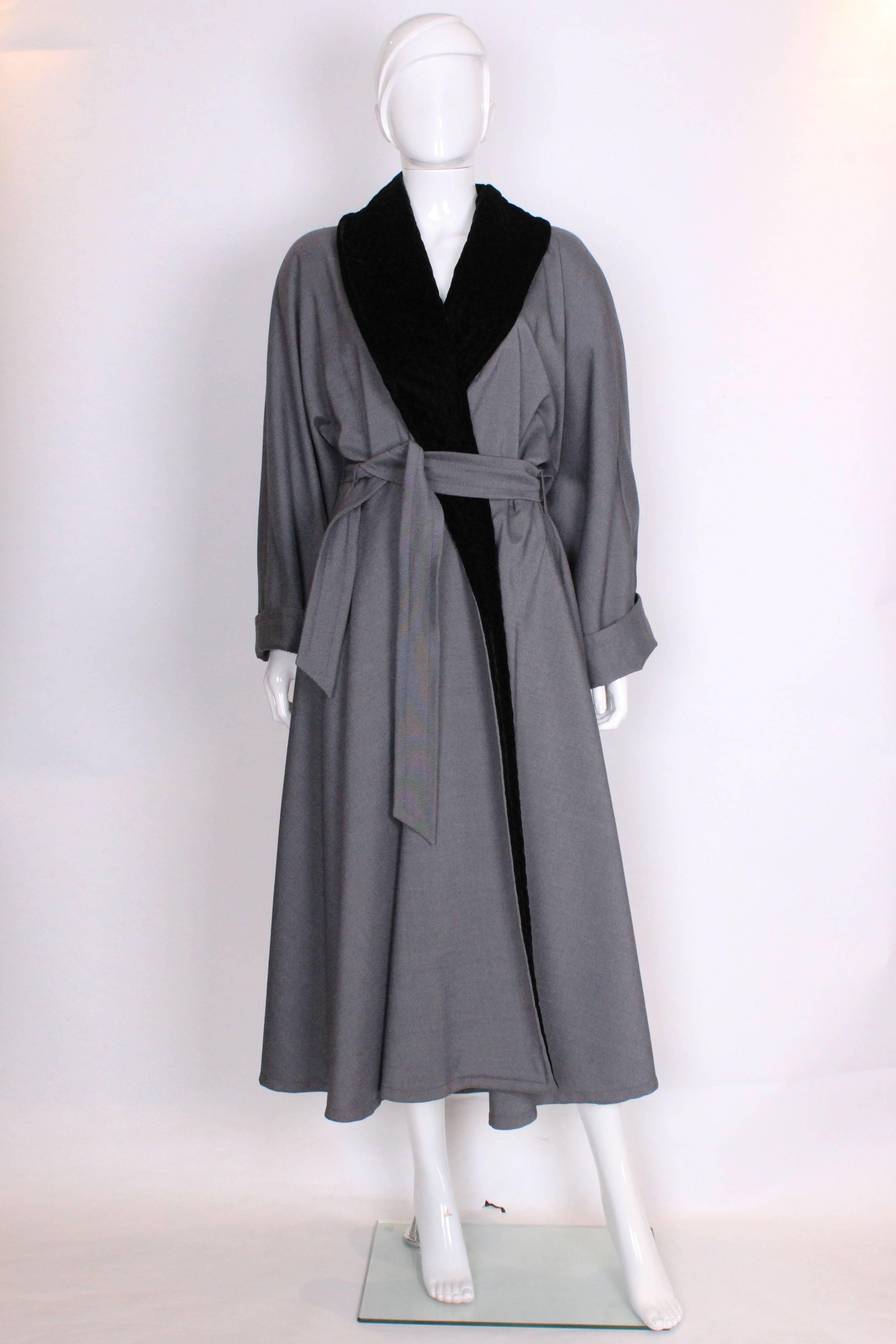 A cosy and chic evening coat by Lanvin Paris.The coat has a wonderful full skirt and so will easily cover most party frocks.The coat is a speckled black, white and grey colour, with a shawl collar of black quilted velvet , a panel of which runs down